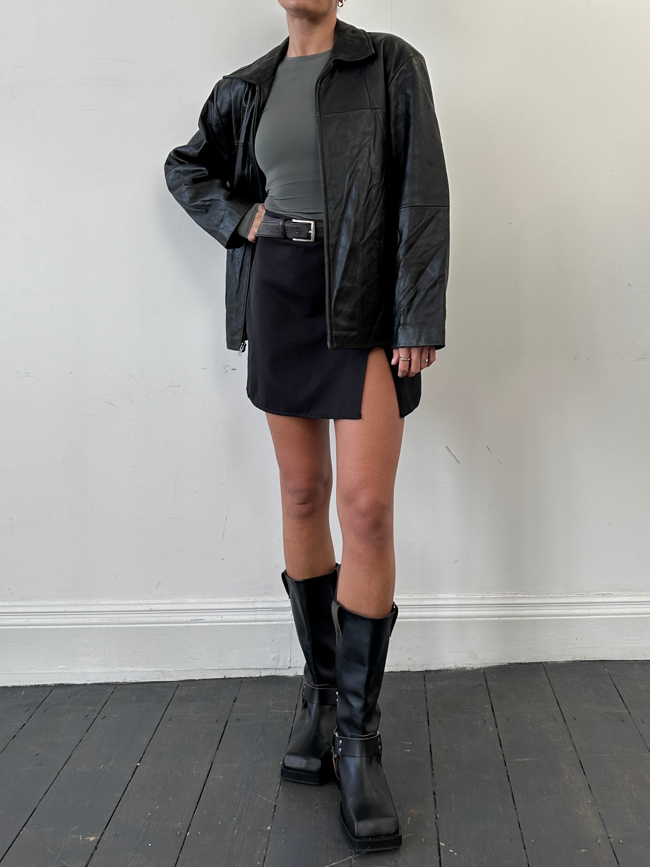 Vintage minimal leather jacket in size M/L, featuring sleek design and classic style, displayed on a hanger in the image.