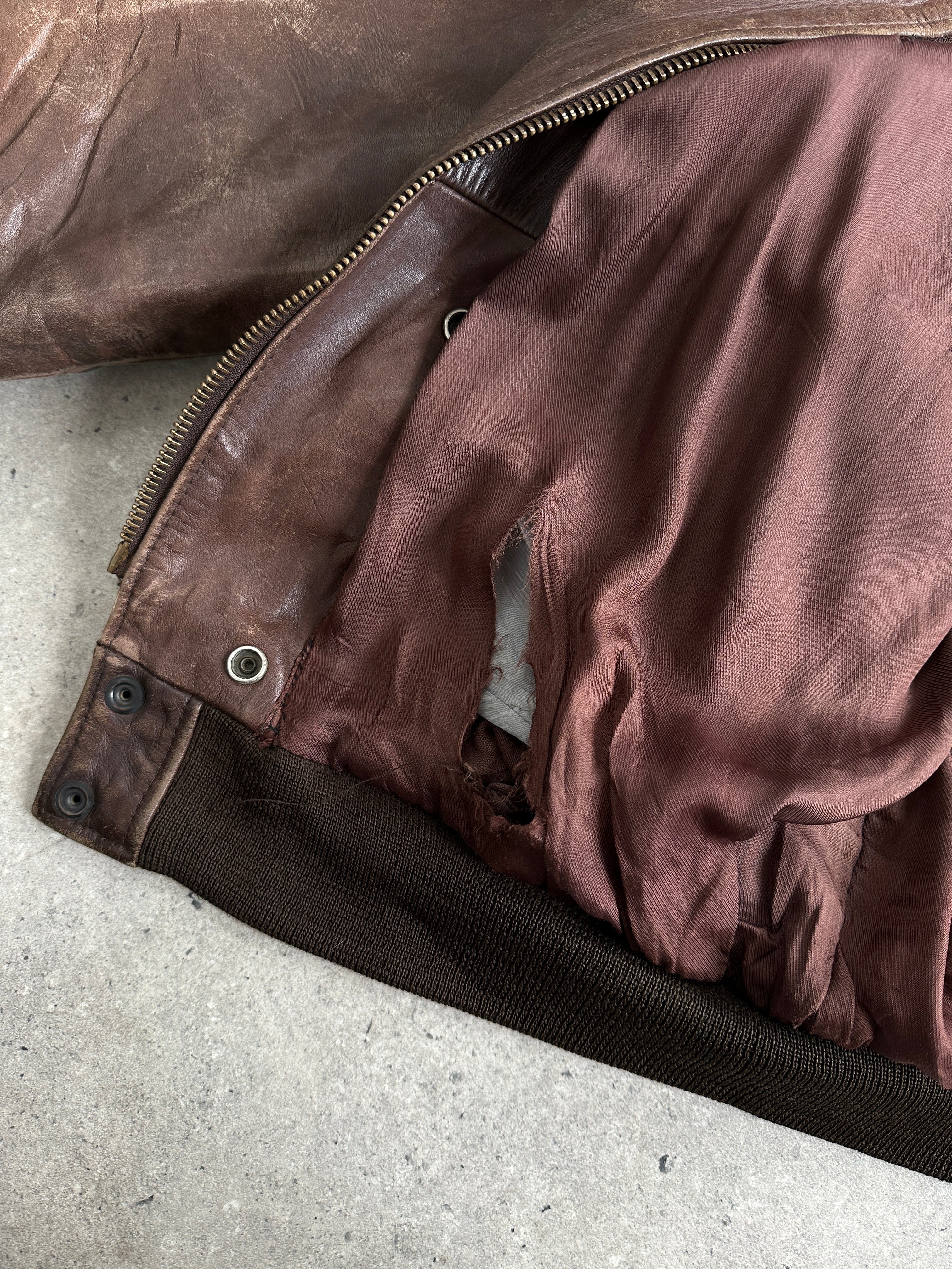 Vintage distressed leather bomber jacket in XL size, featuring a rugged, worn-in look and classic style.