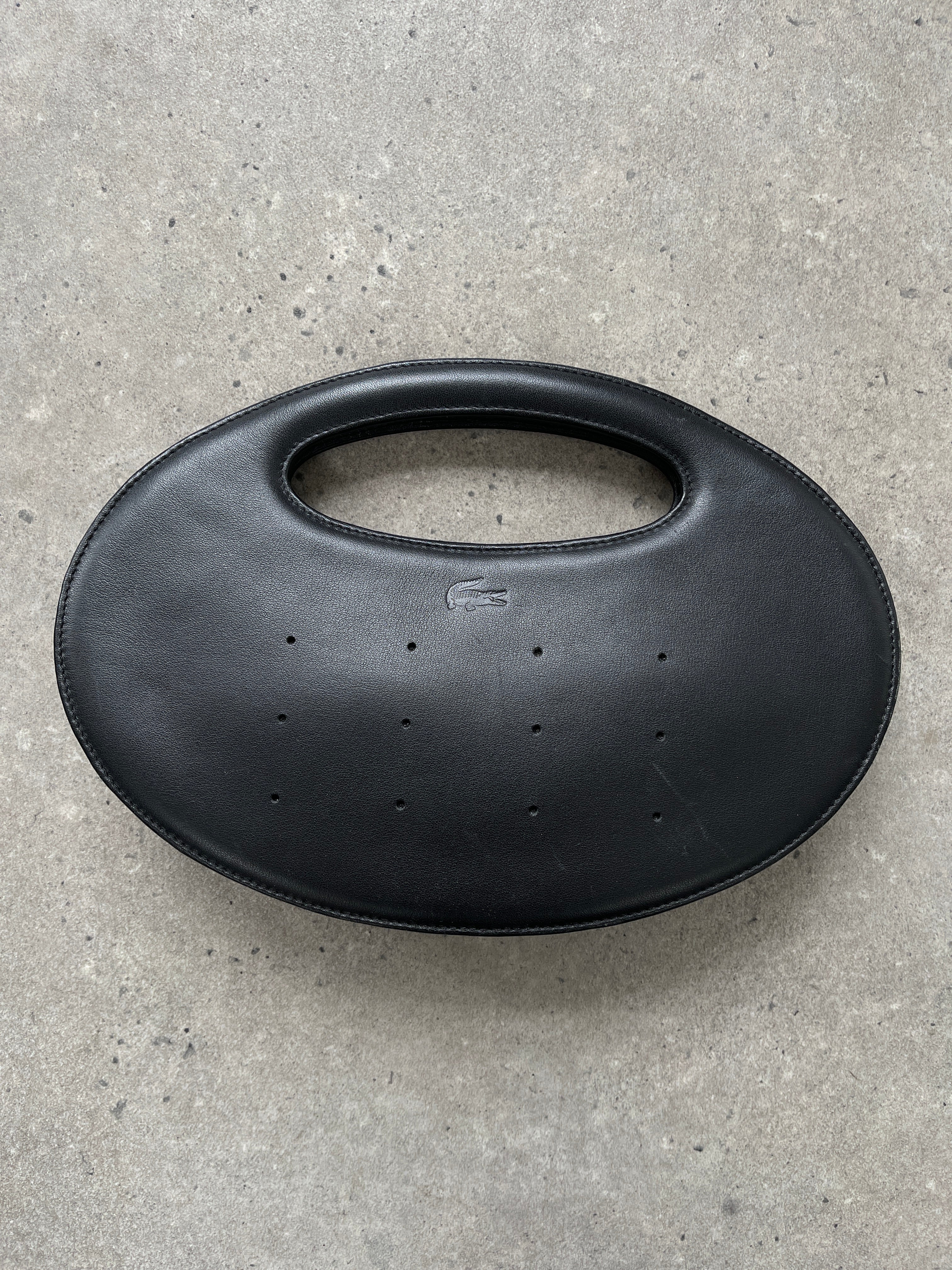 Lacoste 2000s faux leather oval handle bag with structured design and top handle, in a classic style.