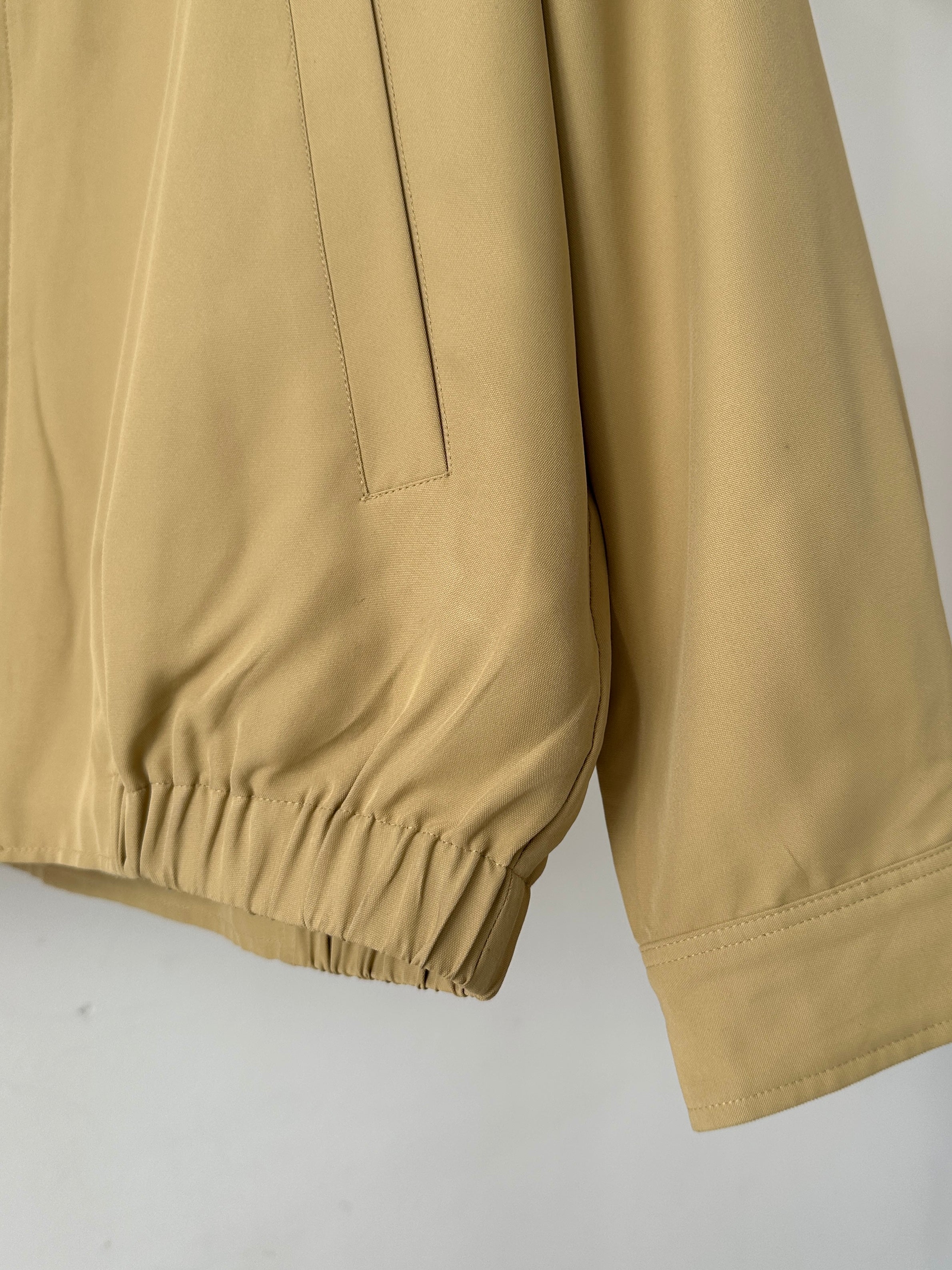 Yves Saint Laurent logo bomber jacket in black with front zipper and ribbed cuffs, displayed on a hanger.