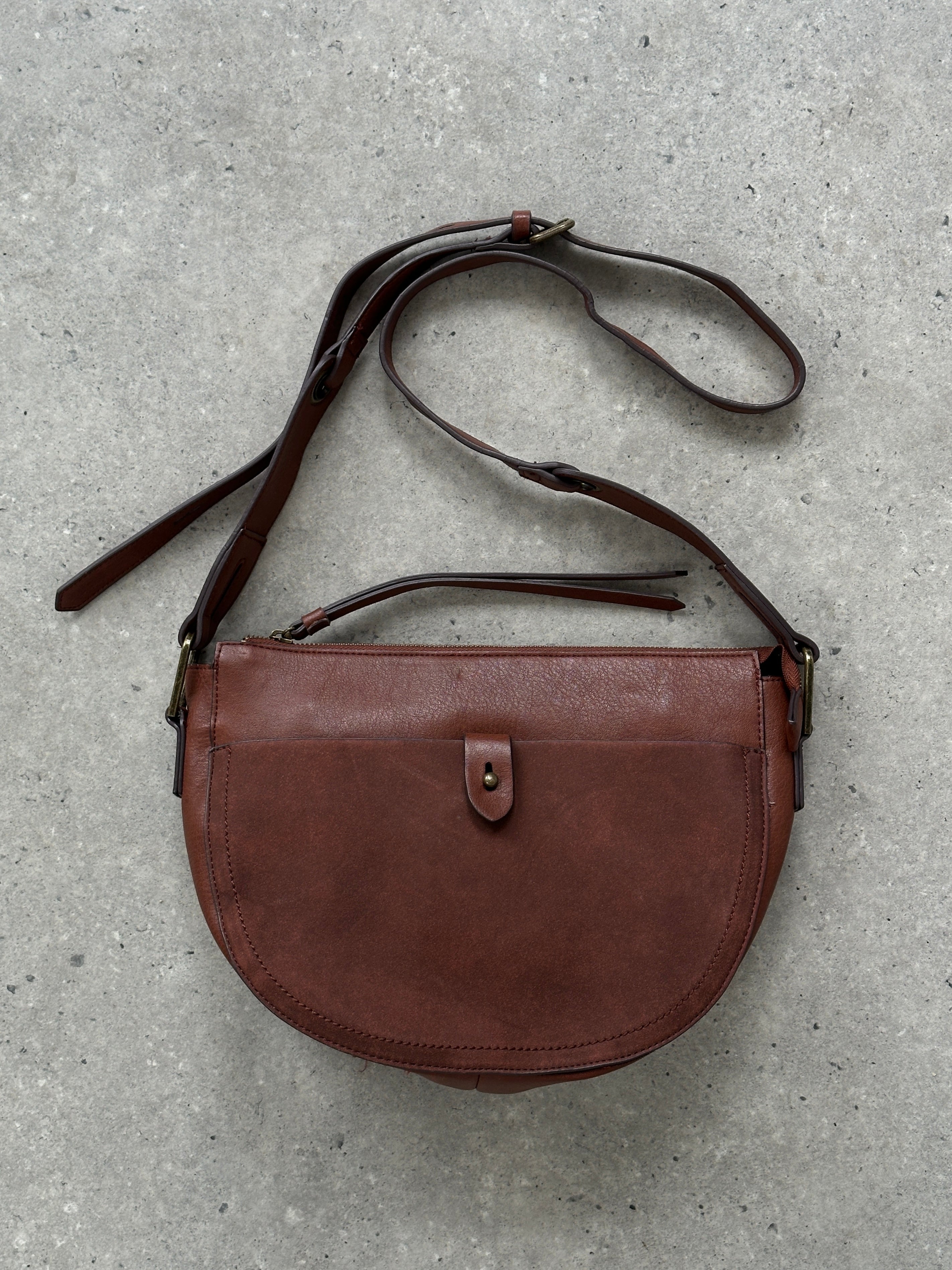 Vintage faux leather crescent crossbody bag with adjustable strap and metal hardware, stylish accessory for casual outfits.