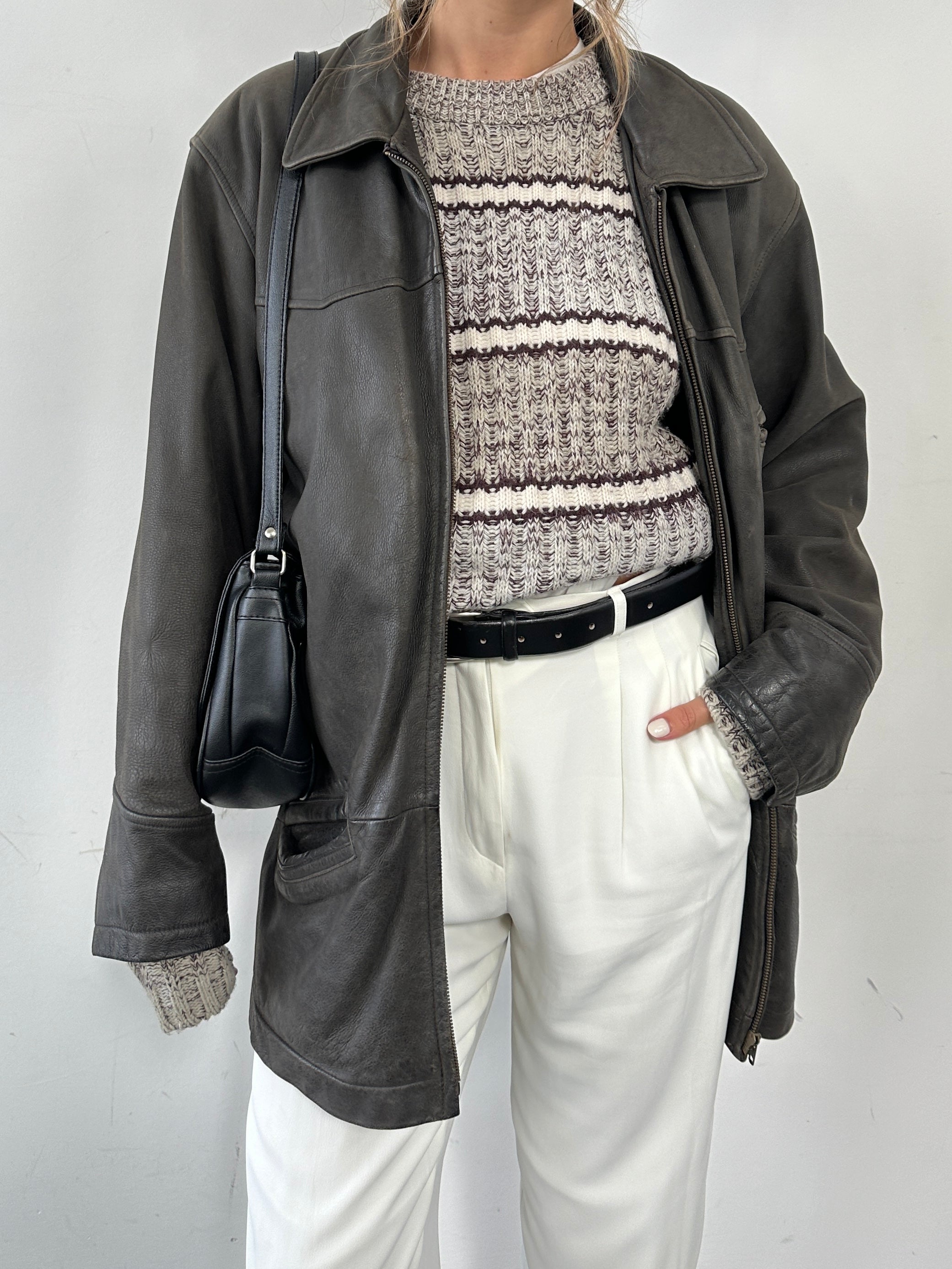 Vintage mid-length leather jacket in size L/XL, featuring classic design and detailed stitching, displayed on a hanger.