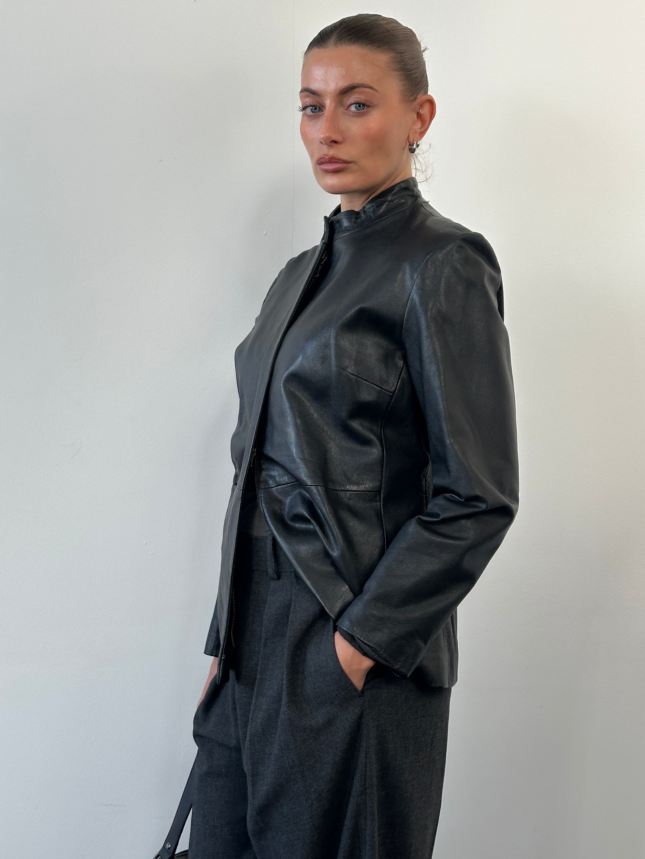 Vintage 1990s minimal round neck leather jacket in size M, showcasing classic black leather with clean, simple design.