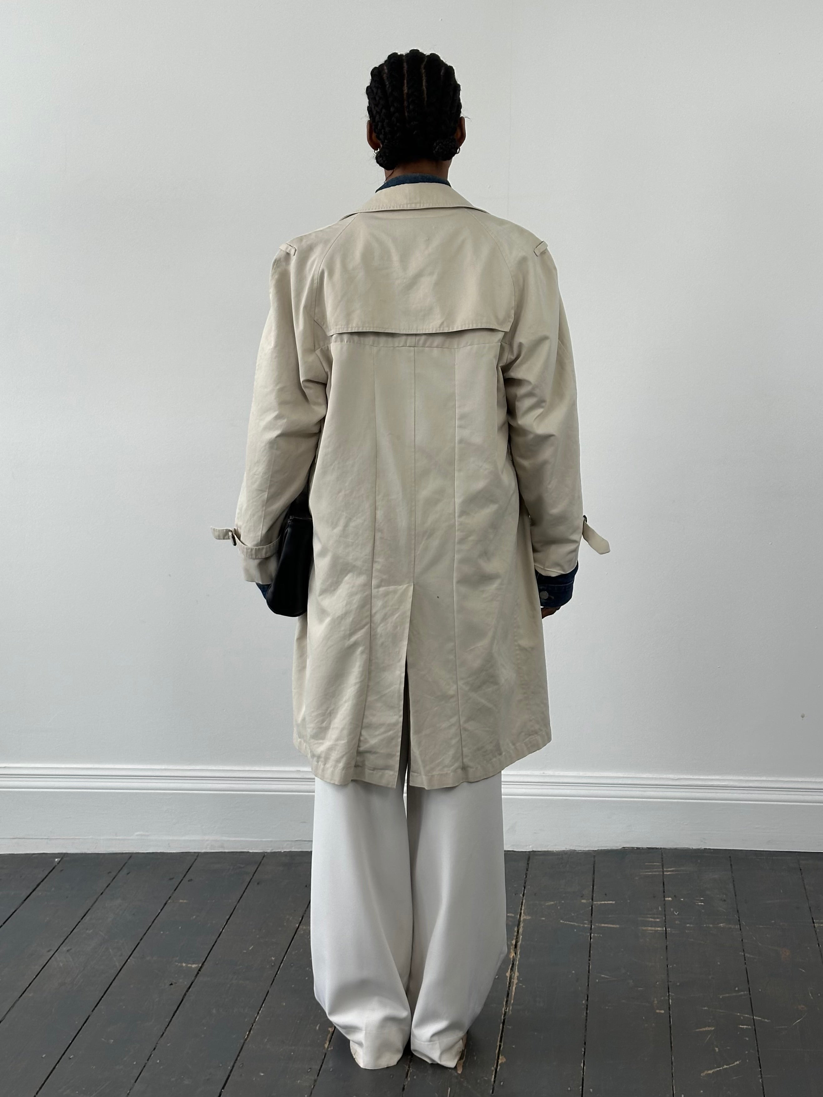 Burberry 1990s cotton double-breasted trench coat in classic beige, displayed on a hanger against a neutral background.