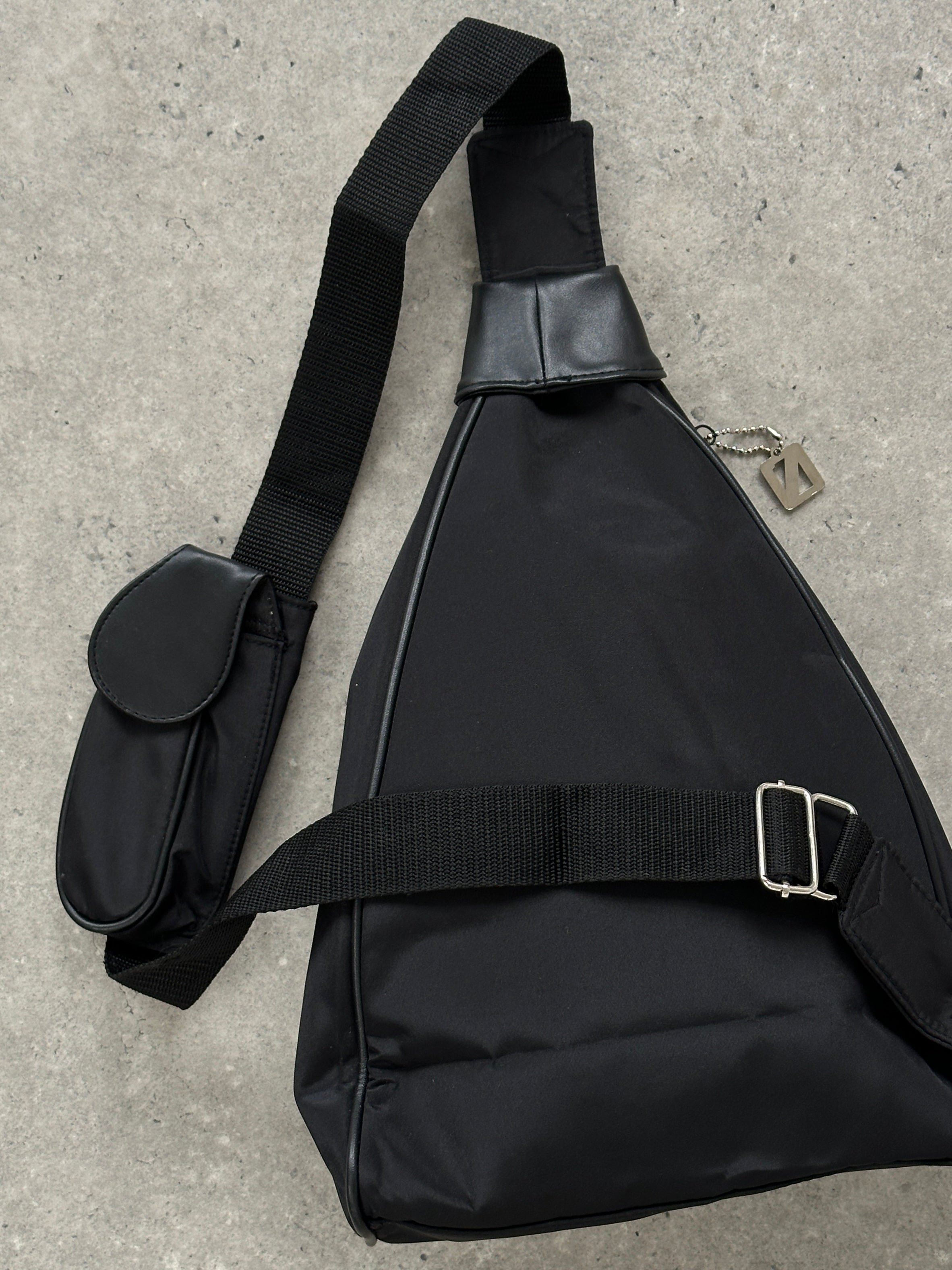 Vintage brand vintage sling bag with adjustable strap and classic design, shown in a close-up image.