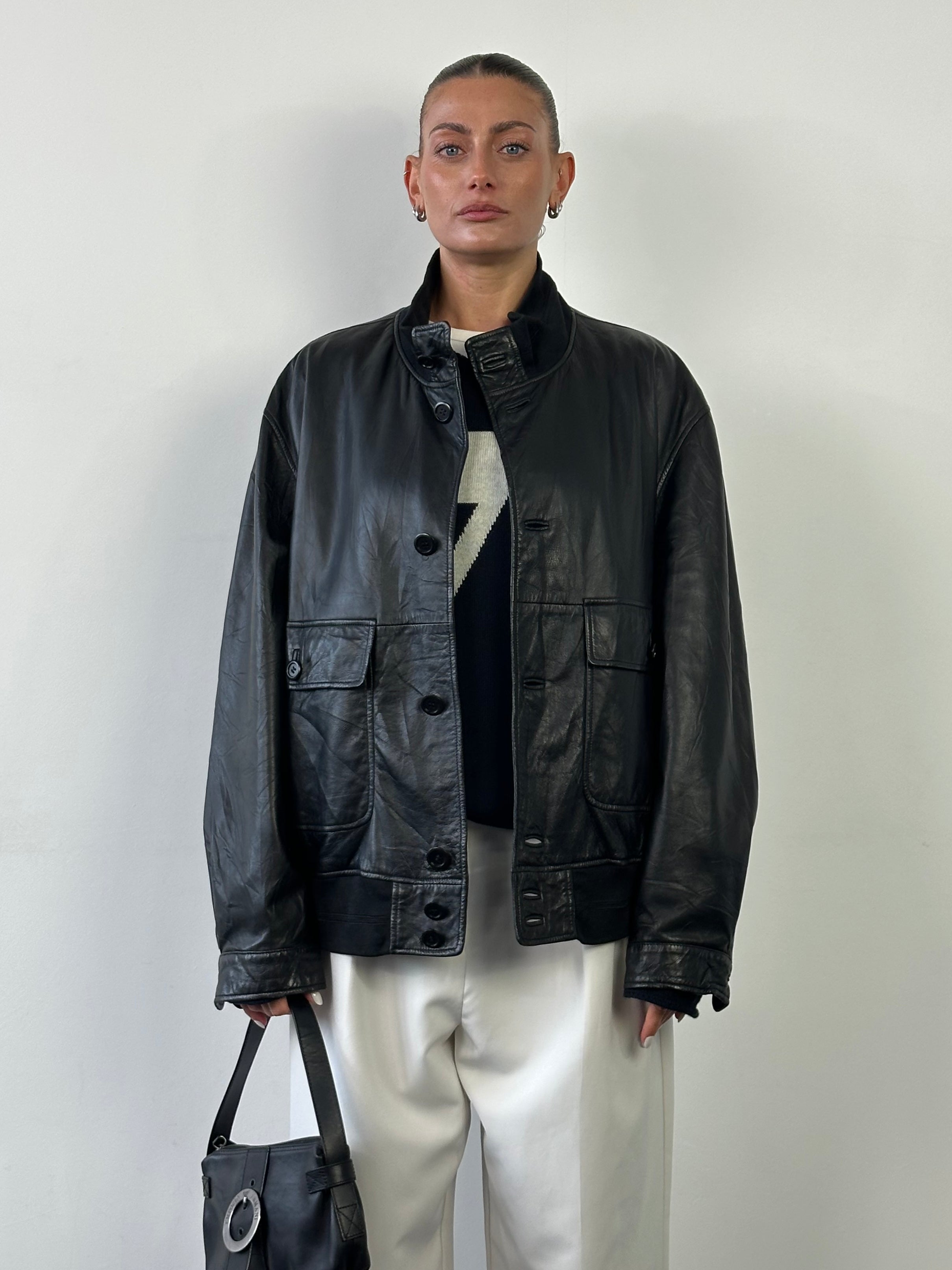Hugo Boss leather bomber jacket in XL, featuring a sleek design, ribbed cuffs, and front zipper, displayed on a hanger.