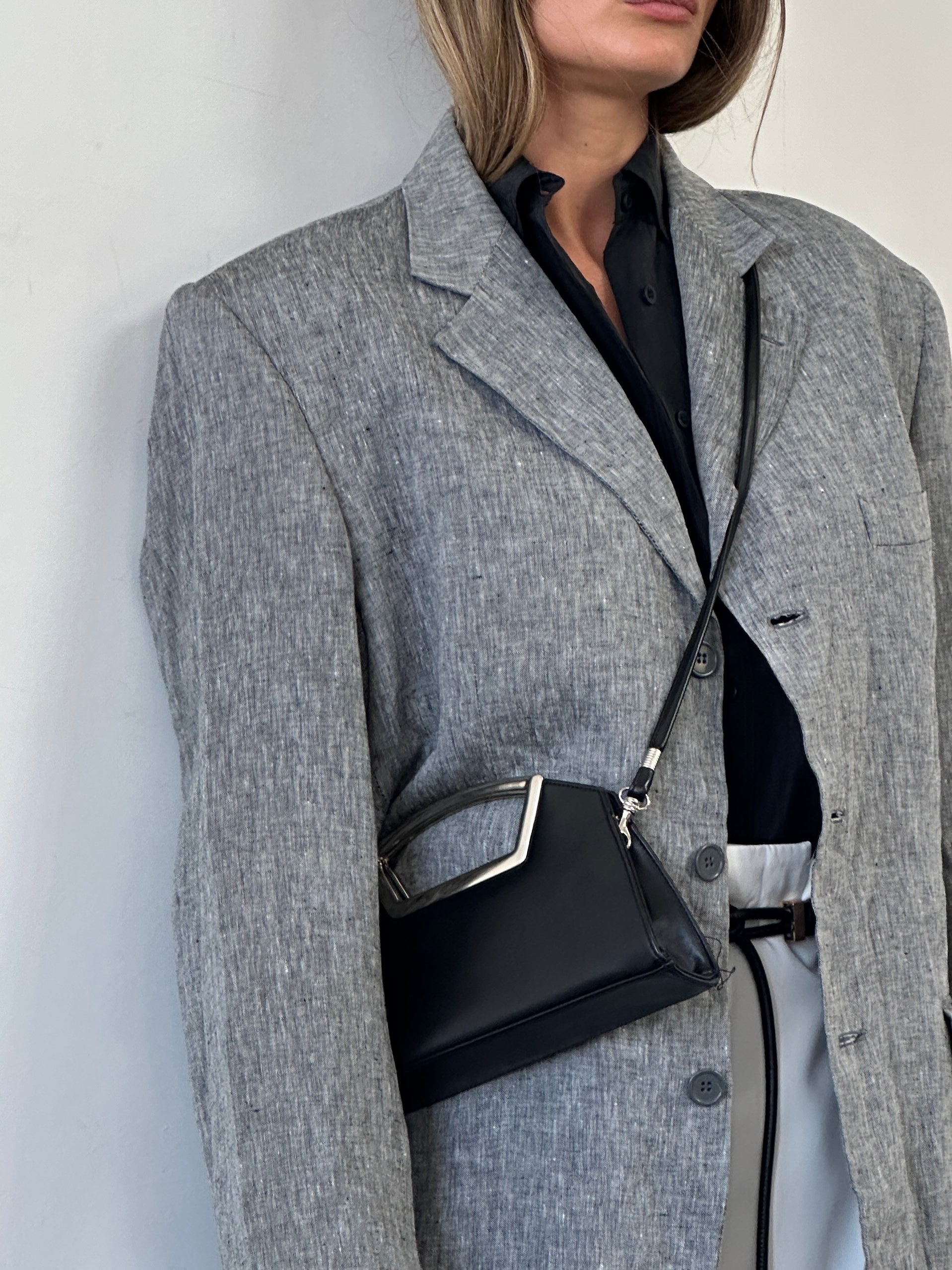 Vintage leather chrome crossbody clutch bag with sleek design and adjustable strap, perfect for stylish everyday use.