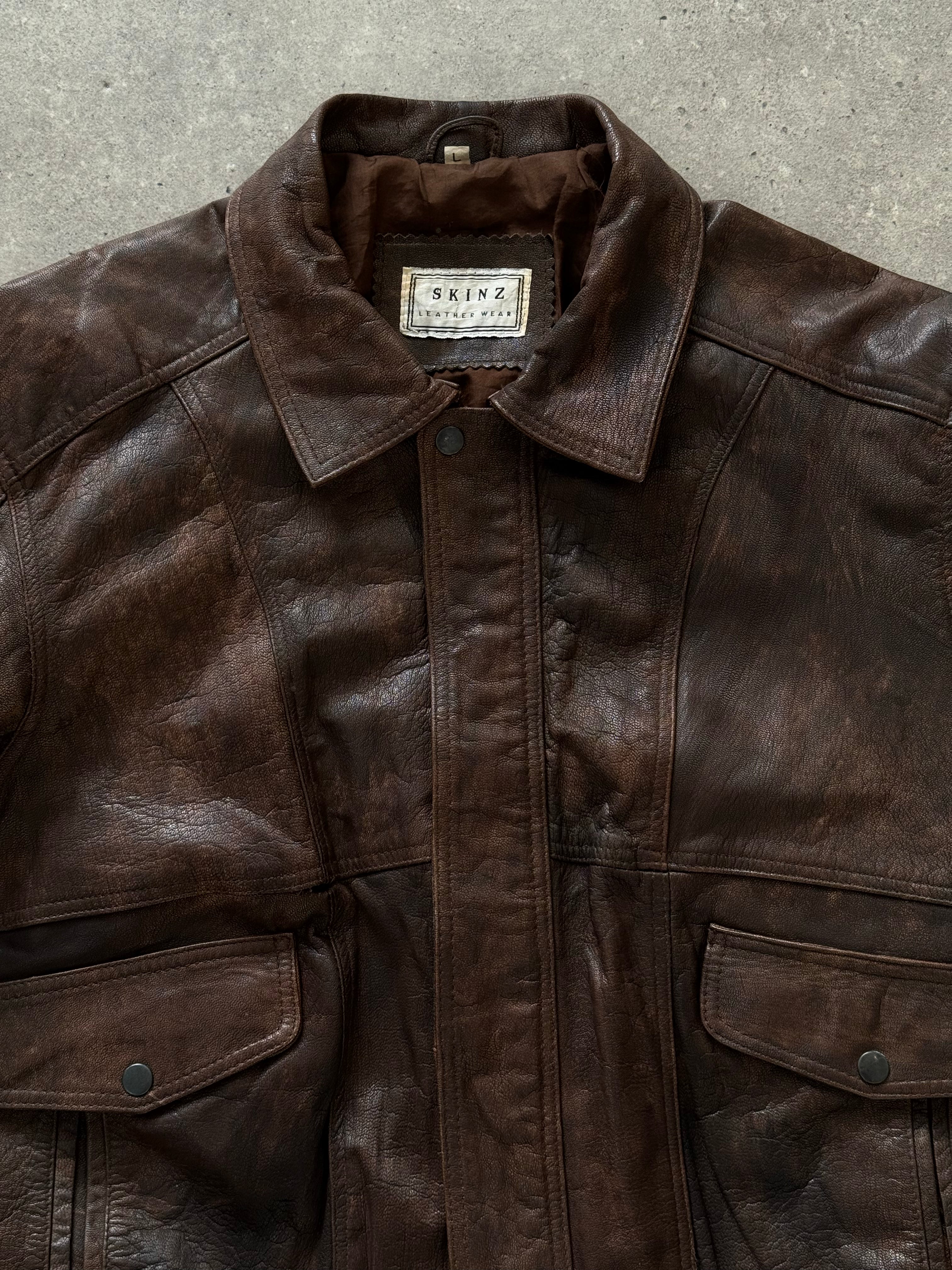 Vintage 1990s distressed leather bomber jacket, size M, with rugged styling and classic design.