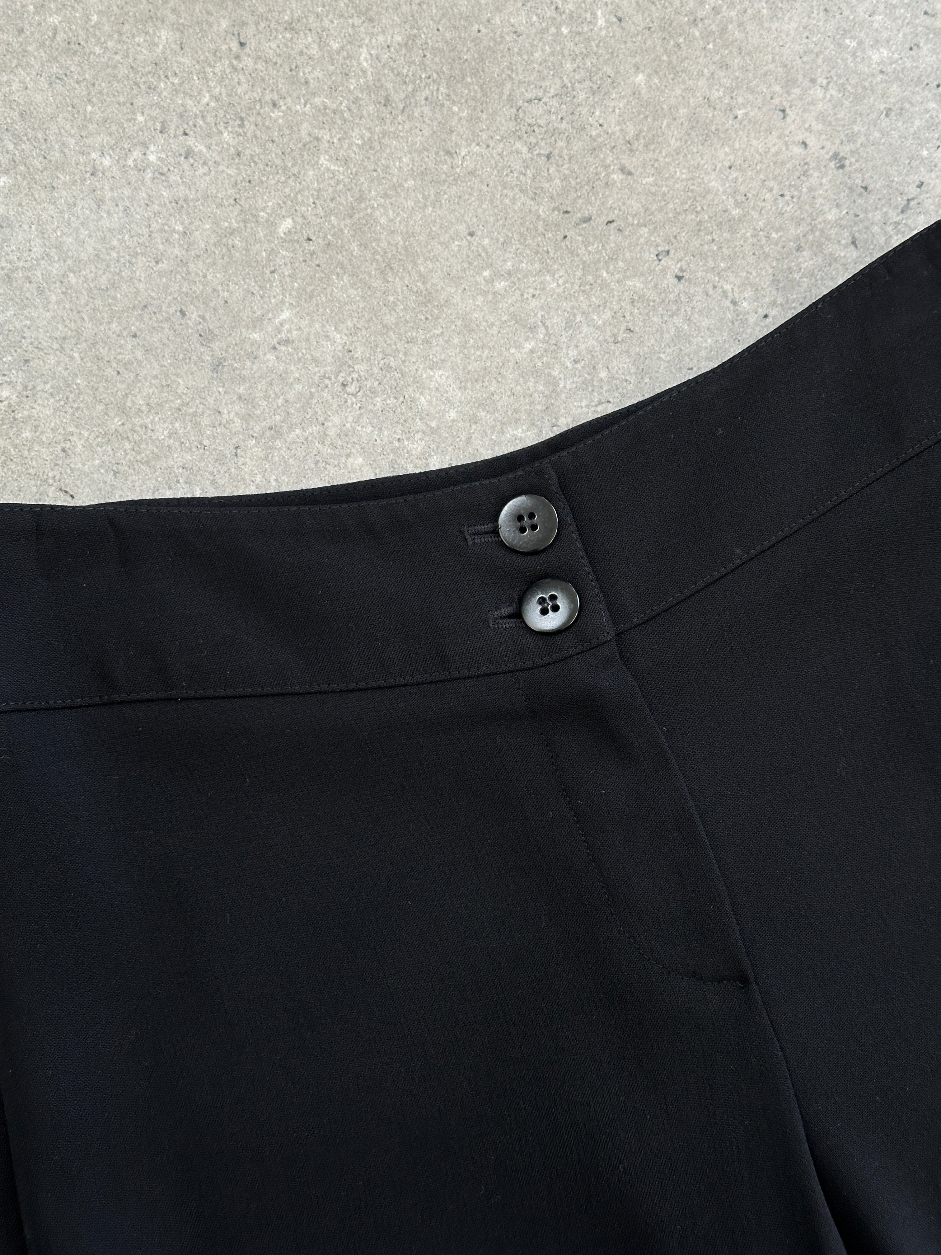 Armani Collezioni wool trousers with low waist and wide leg fit, shown in a natural fabric and stylish cut.