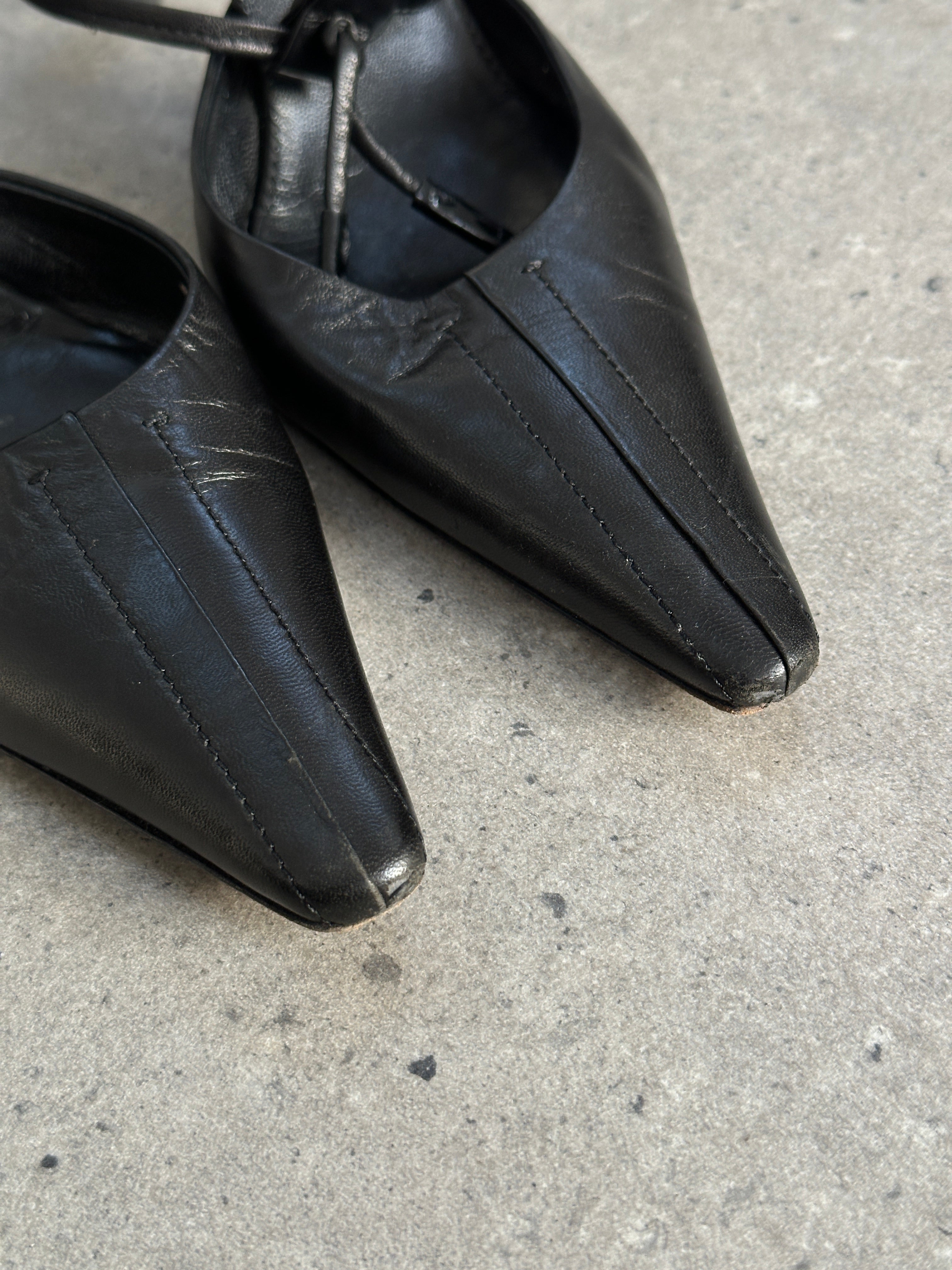 Prada pointed toe high heels in black leather, UK 7.5, with sleek stiletto design and elegant finish.
