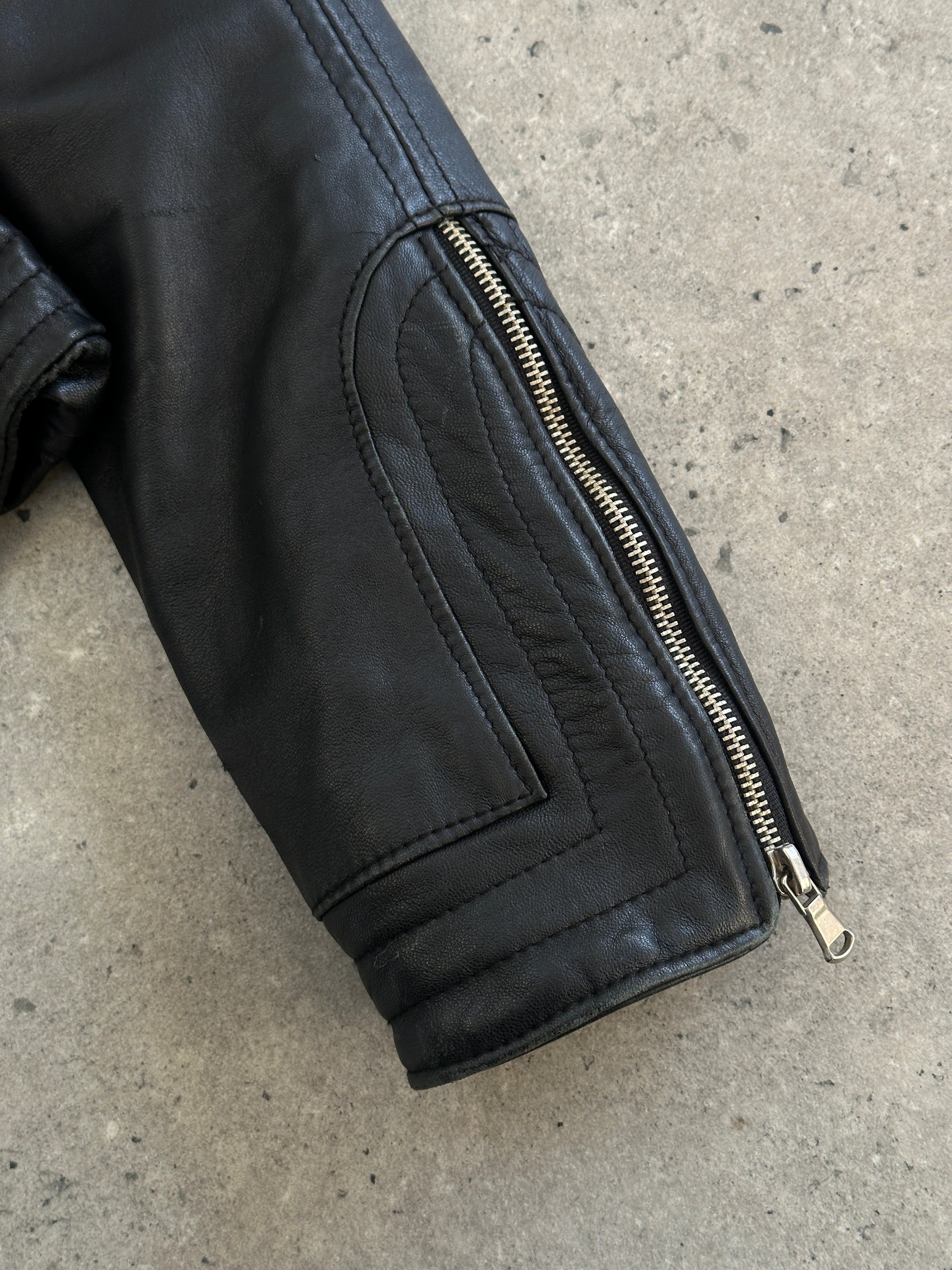 Vintage Italian 1990s fitted leather jacket with buckled details, showcasing classic vintage style and authentic leather texture.