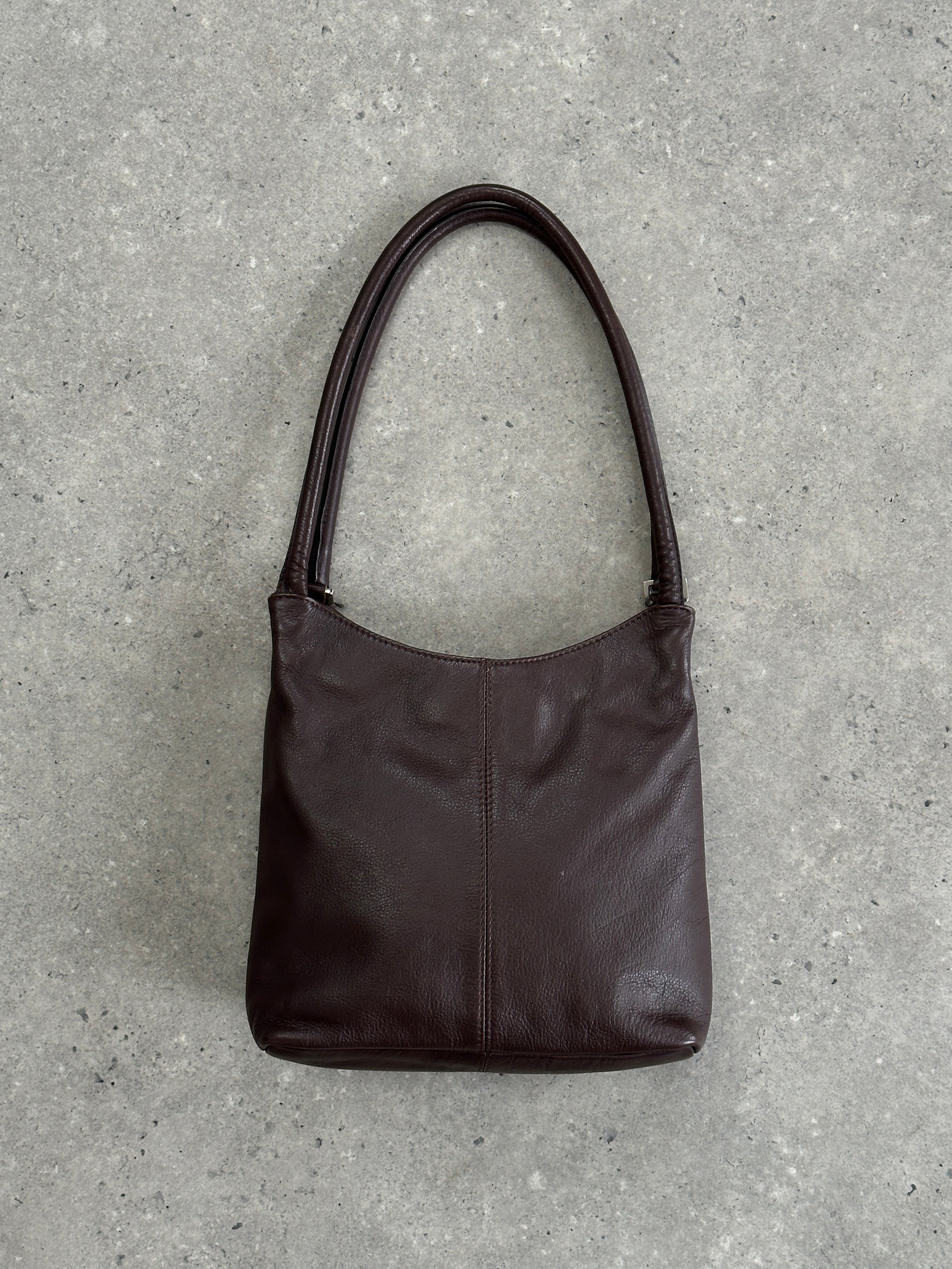 Vintage leather shoulder bag with adjustable strap and rustic finish, showcasing classic design and durable craftsmanship.