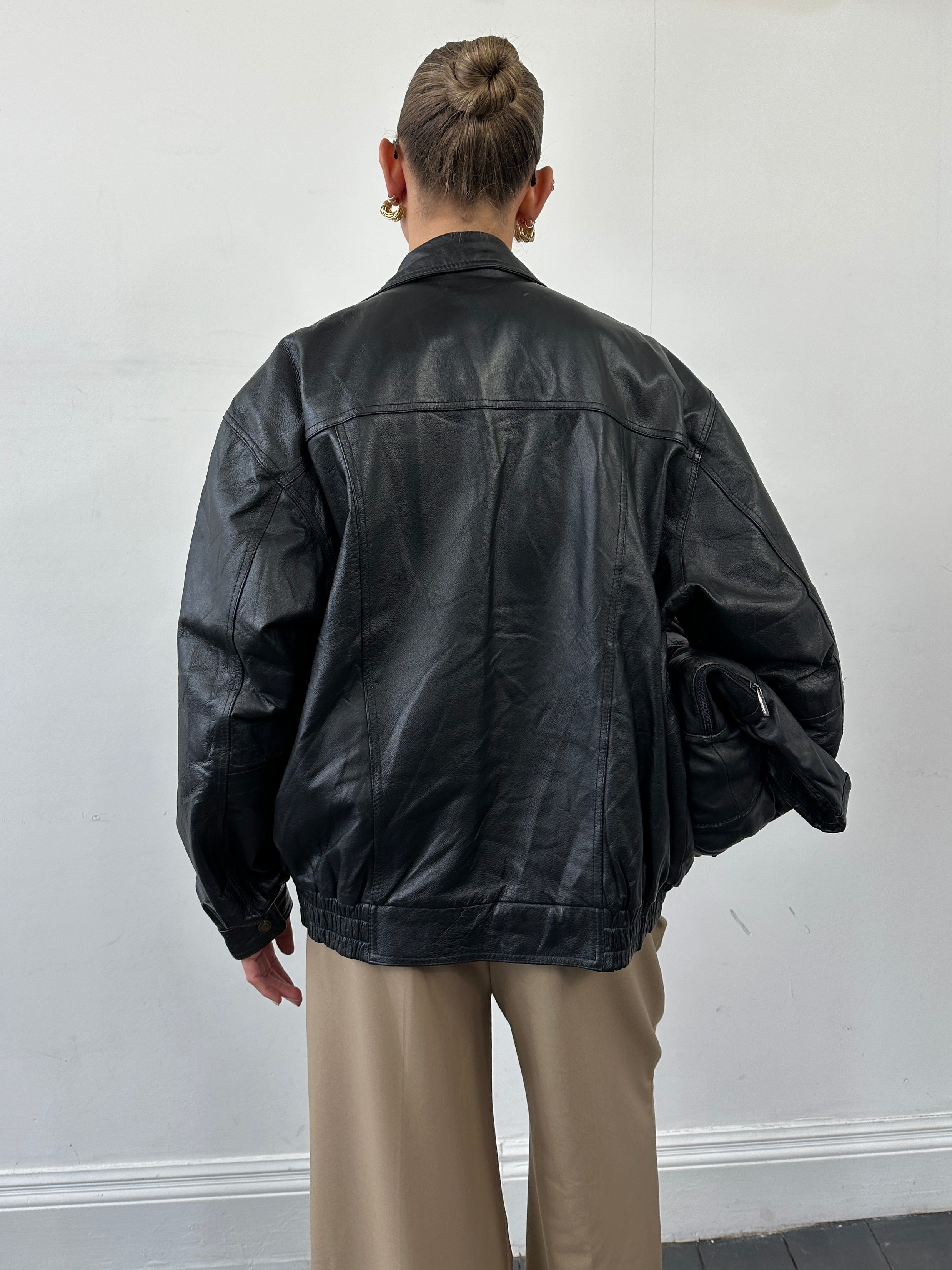 Vintage leather bomber jacket in XL size, featuring classic design with a worn-in leather finish and ribbed cuffs and collar.