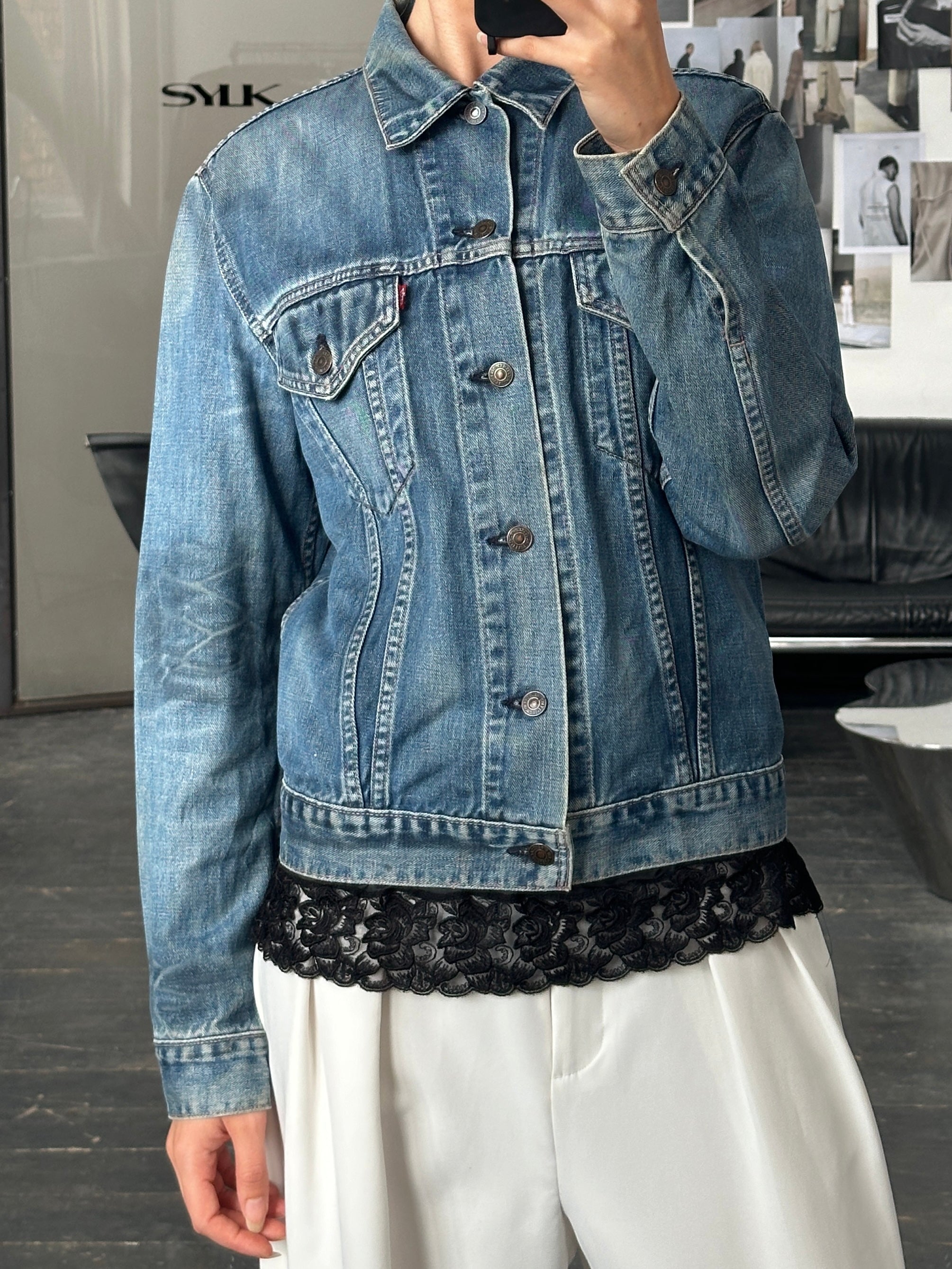 Levi’s 1990s faded denim jacket, men's size M, featuring a classic blue wash and vintage style, displayed on a hanger.