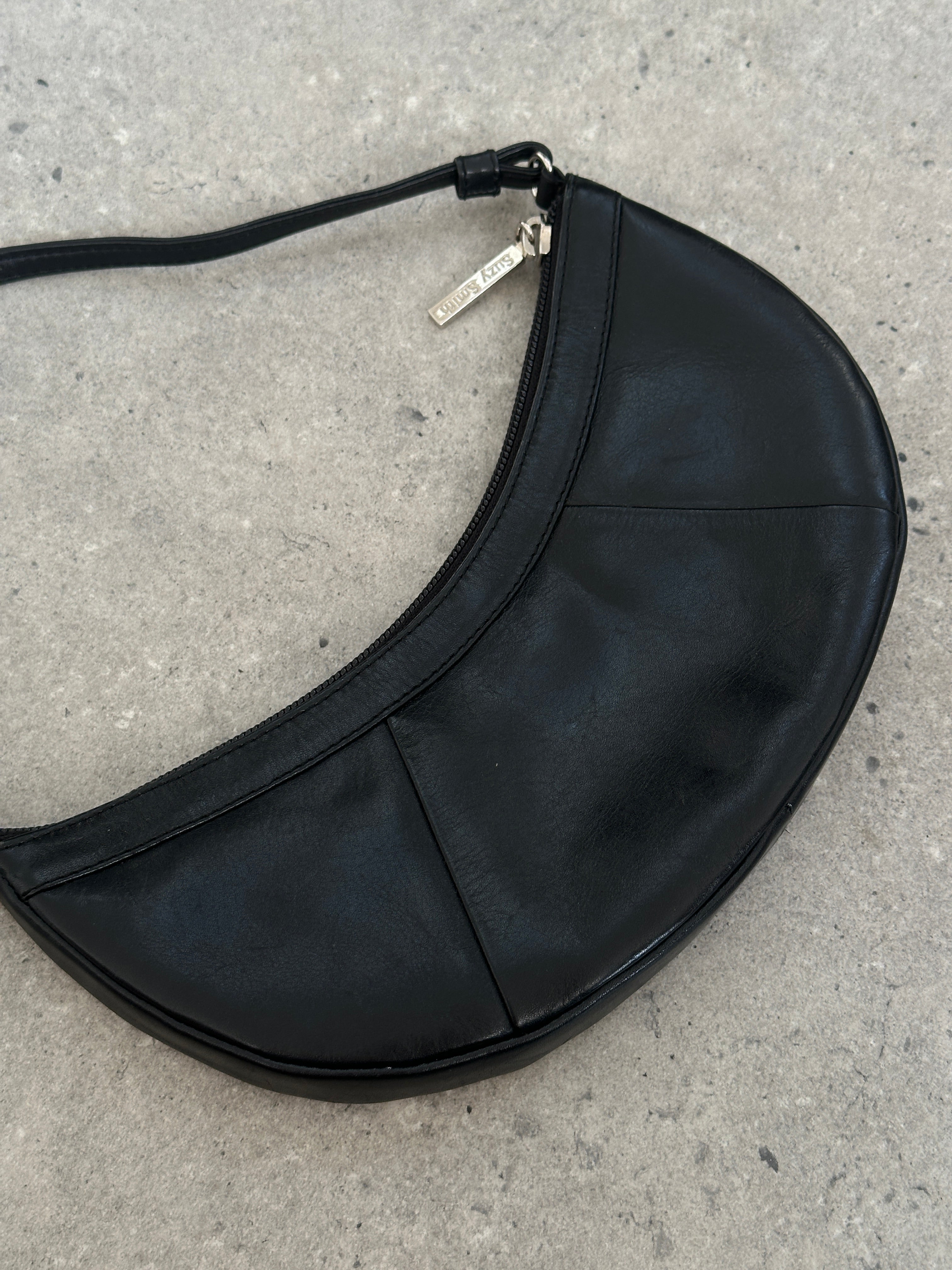 Vintage leather crescent shoulder bag with adjustable strap and antique finish, stylish accessory for everyday use