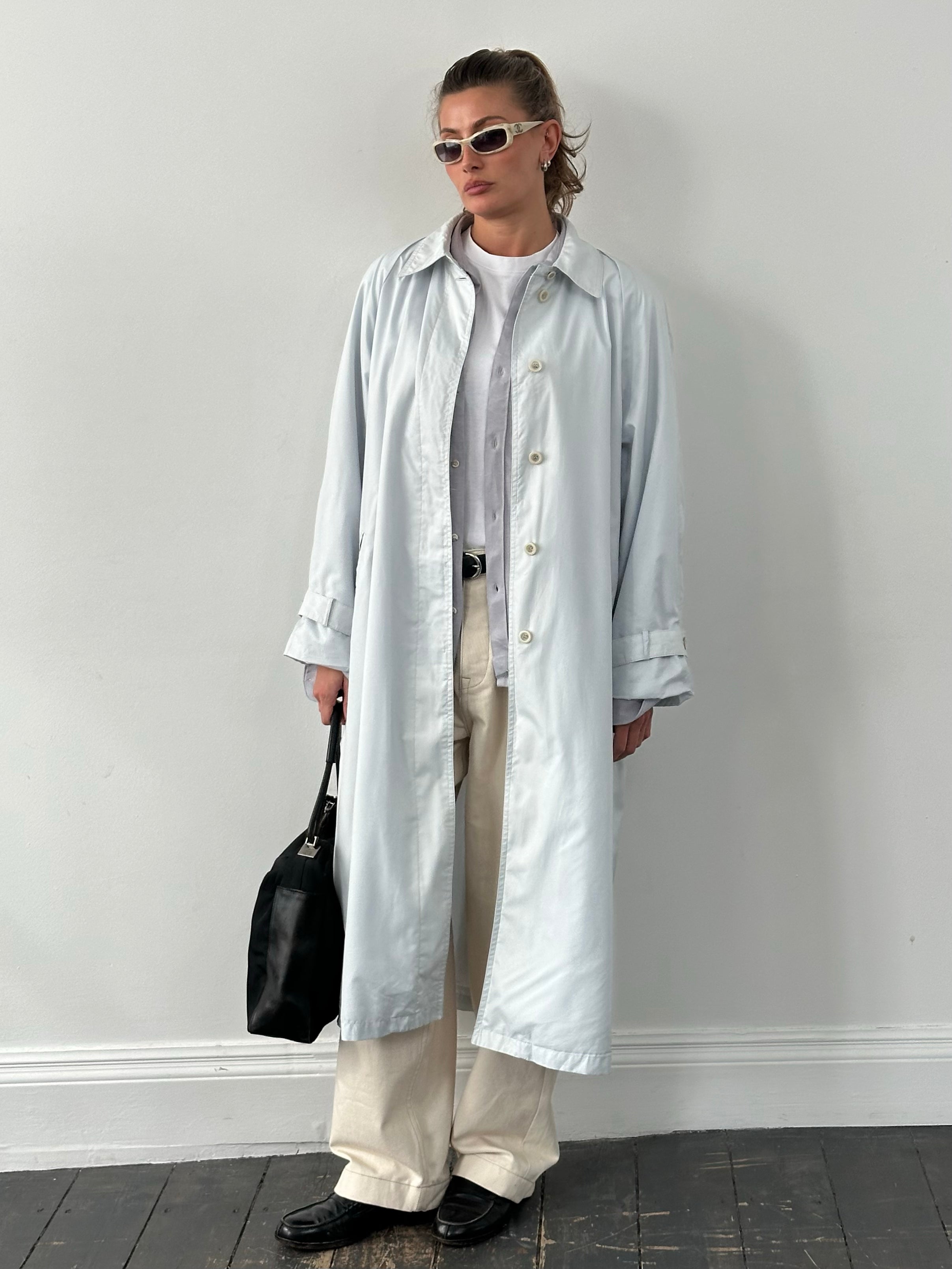 London Fog 1990s XL trench coat with concealed placket, classic beige color, shown hanging on a wooden hanger.