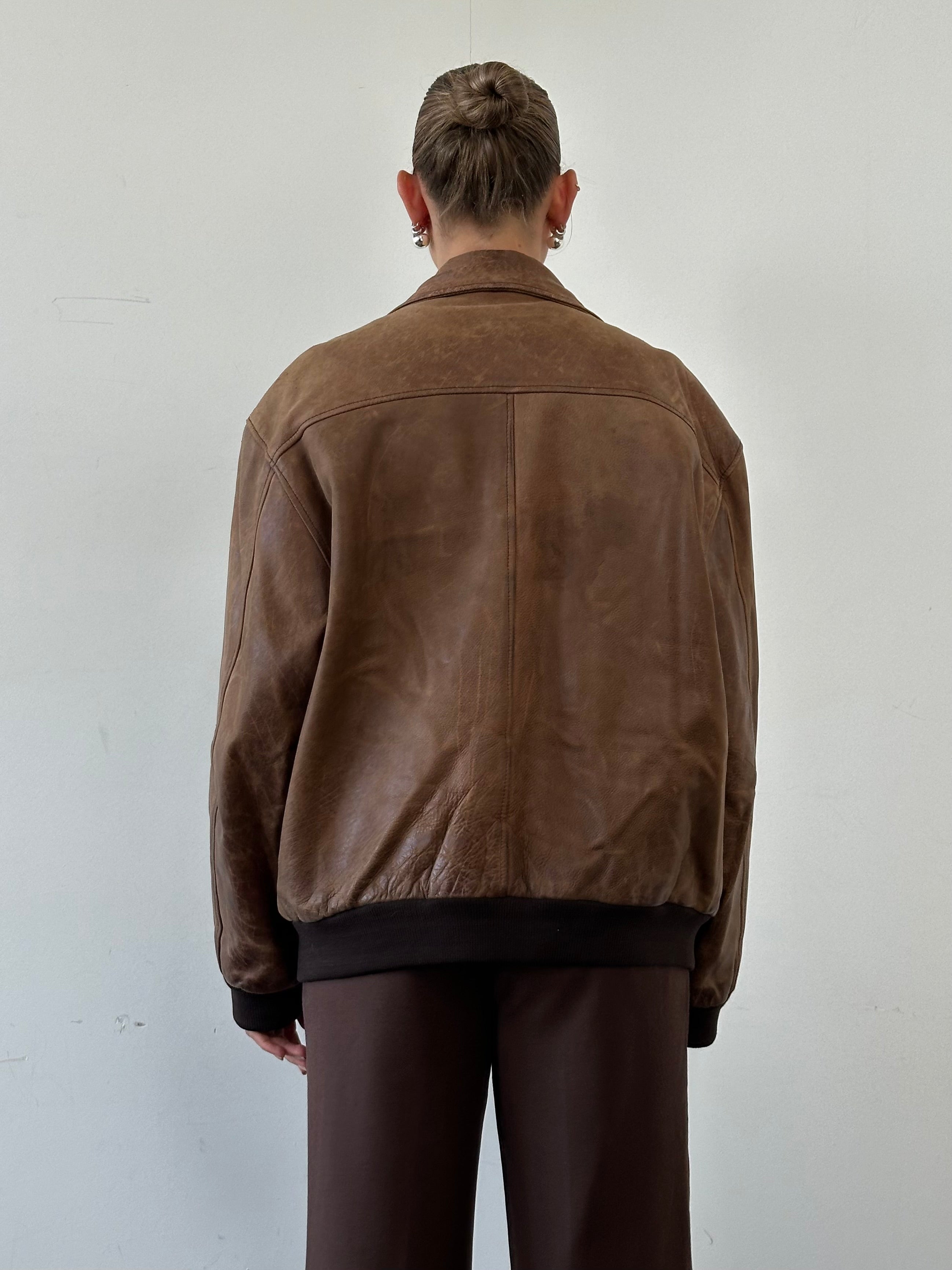 Vintage distressed leather bomber jacket in XL size, featuring a rugged look and classic style, shown in the image.