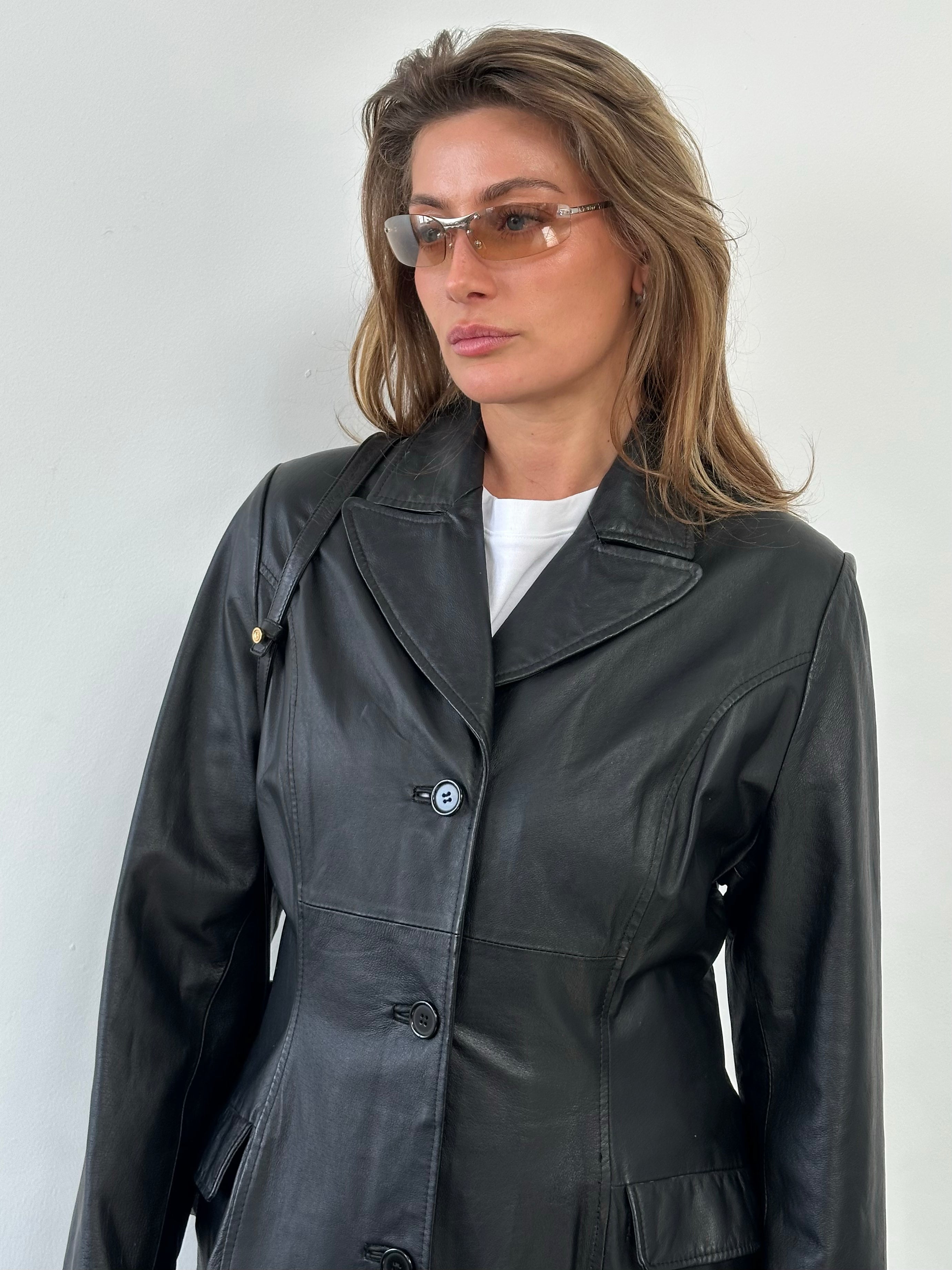 Vintage 1980s leather trench coat, floor length, medium size, featuring classic trench design and dark brown leather material.