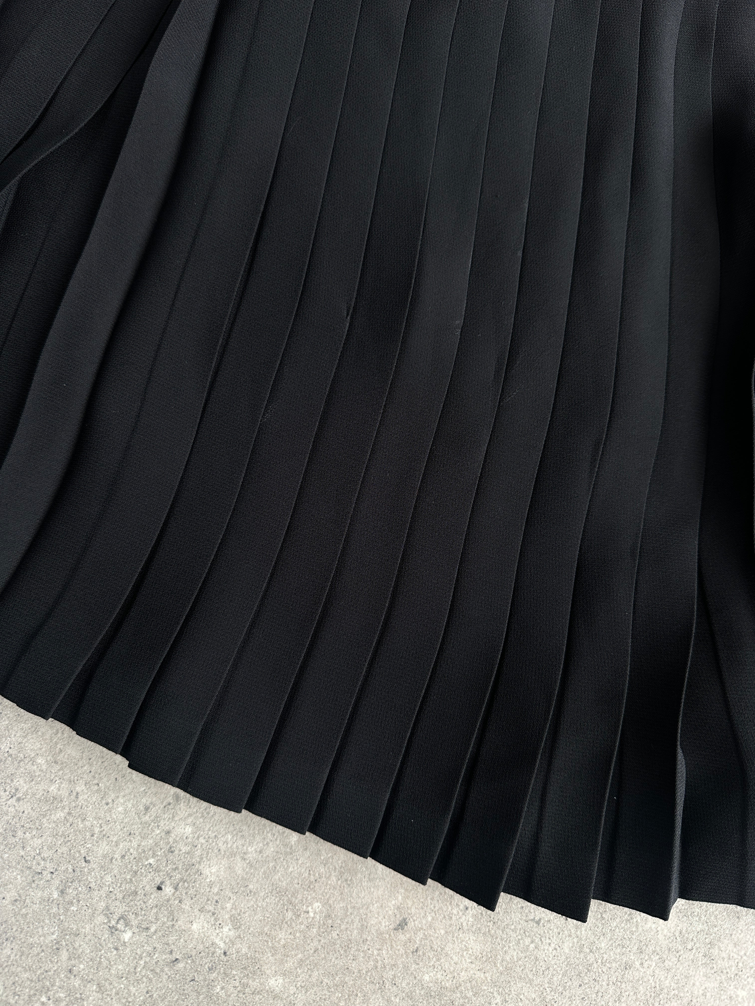 Vintage Italian 1990s pleated A-line mini skirt in W26 size, showcasing classic retro style and lightweight fabric.