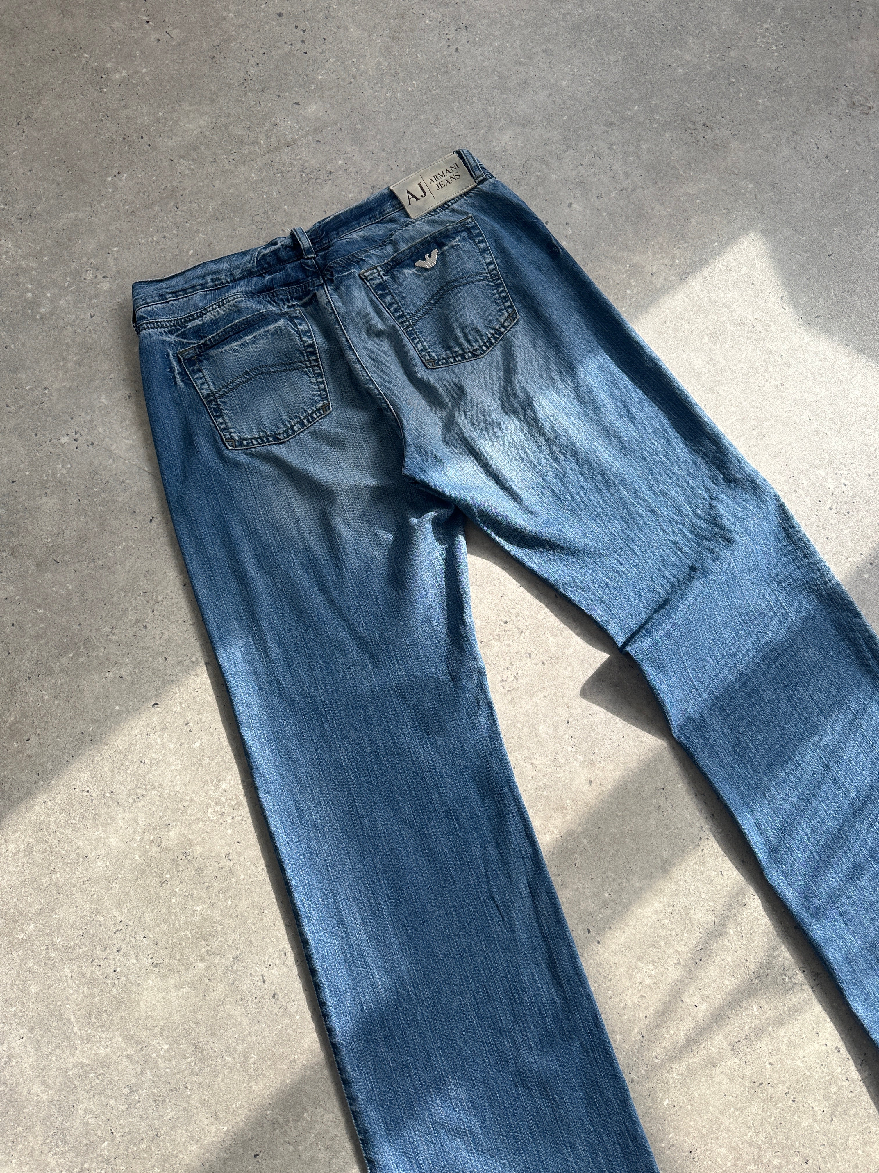 Armani Jeans stonewashed mid-rise denim jeans in size W34, showing classic blue color and casual fit.