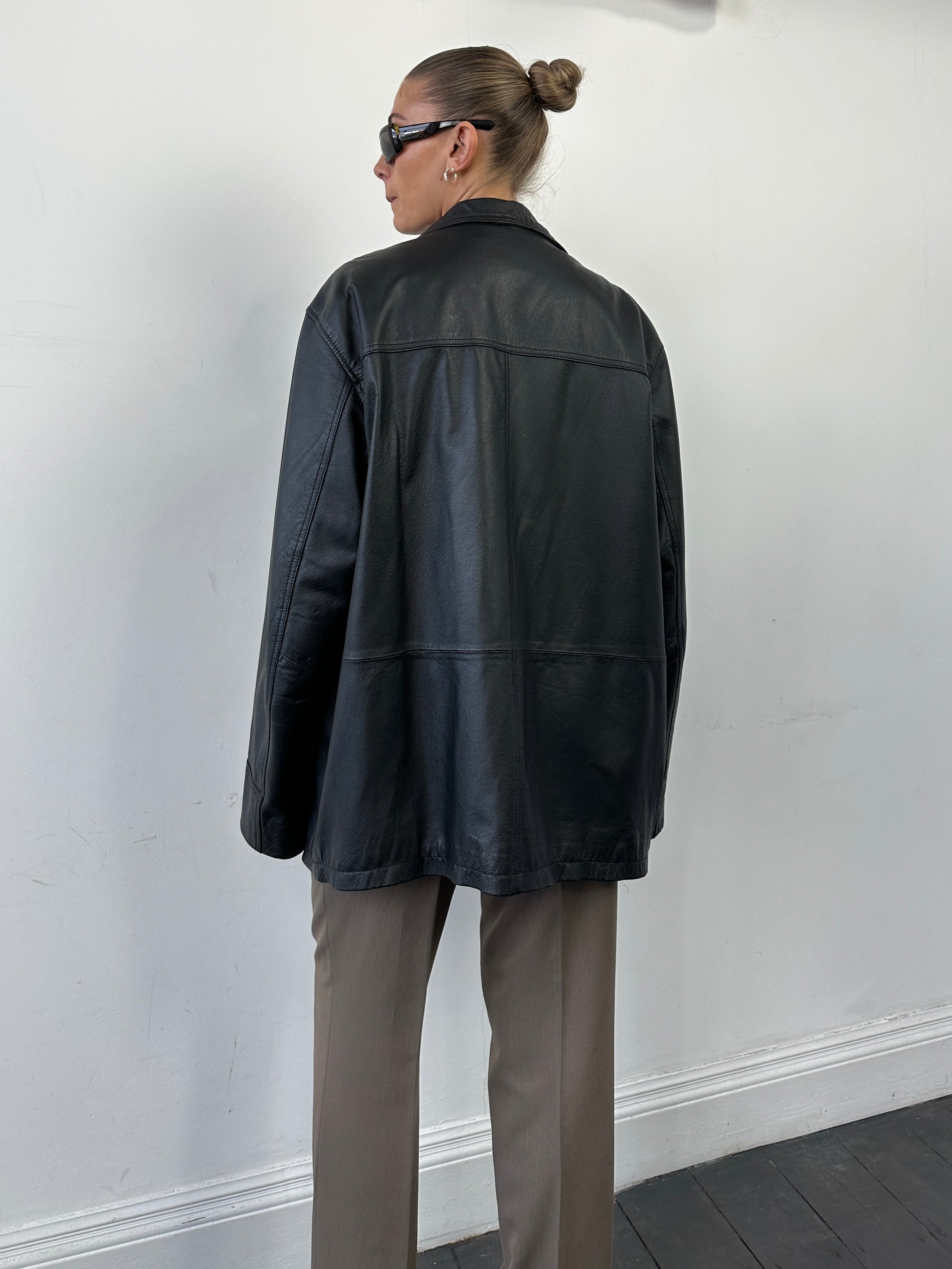 Vintage minimal leather jacket in XL size, featuring classic design and smooth leather material, displayed on a hanger.