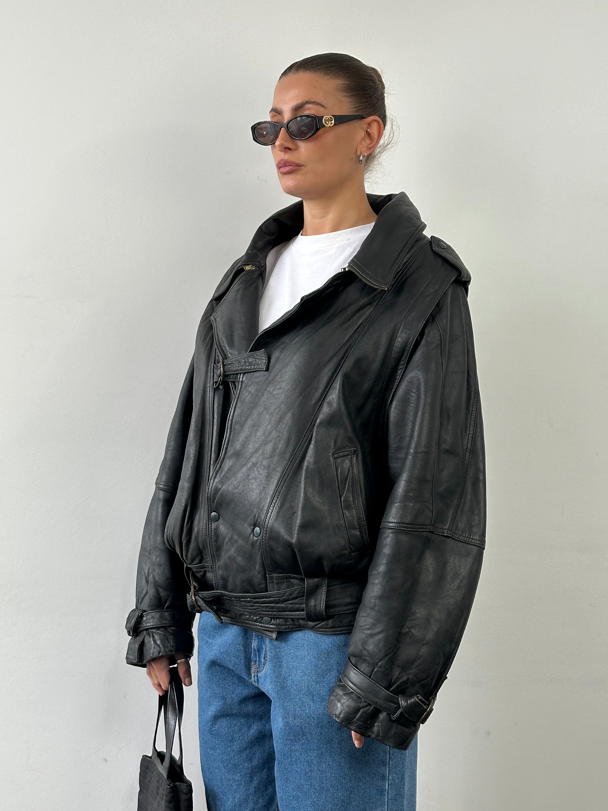 Vintage leather jacket with belted buckle in XL size, featuring classic design and durable leather material.