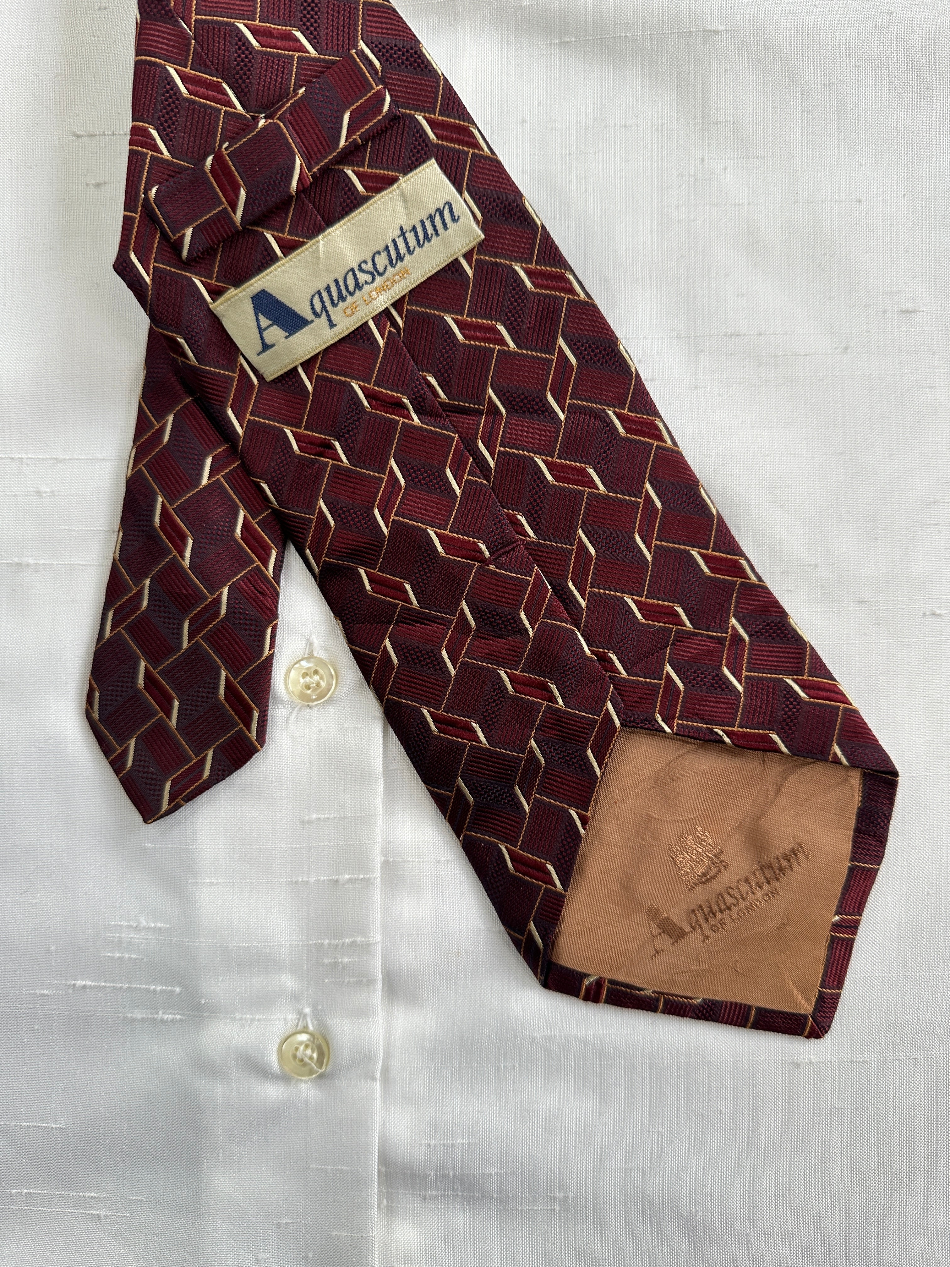 Aquascutum 1990s pure silk tie featuring a classic patterned design, showcasing luxurious fabric and elegant craftsmanship.