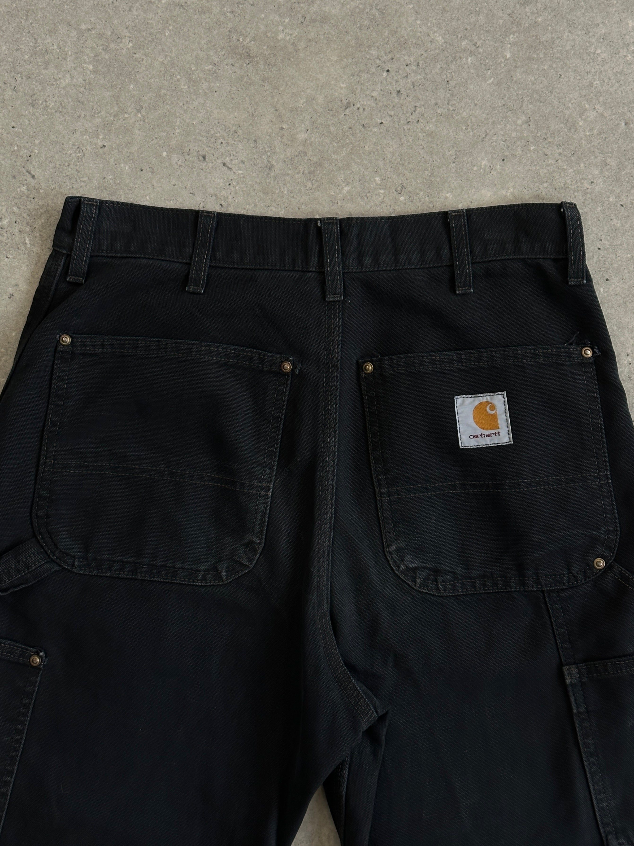 Carhartt high waisted cargo denim jeans in W30 with multiple pockets and classic blue wash, styled for casual wear.
