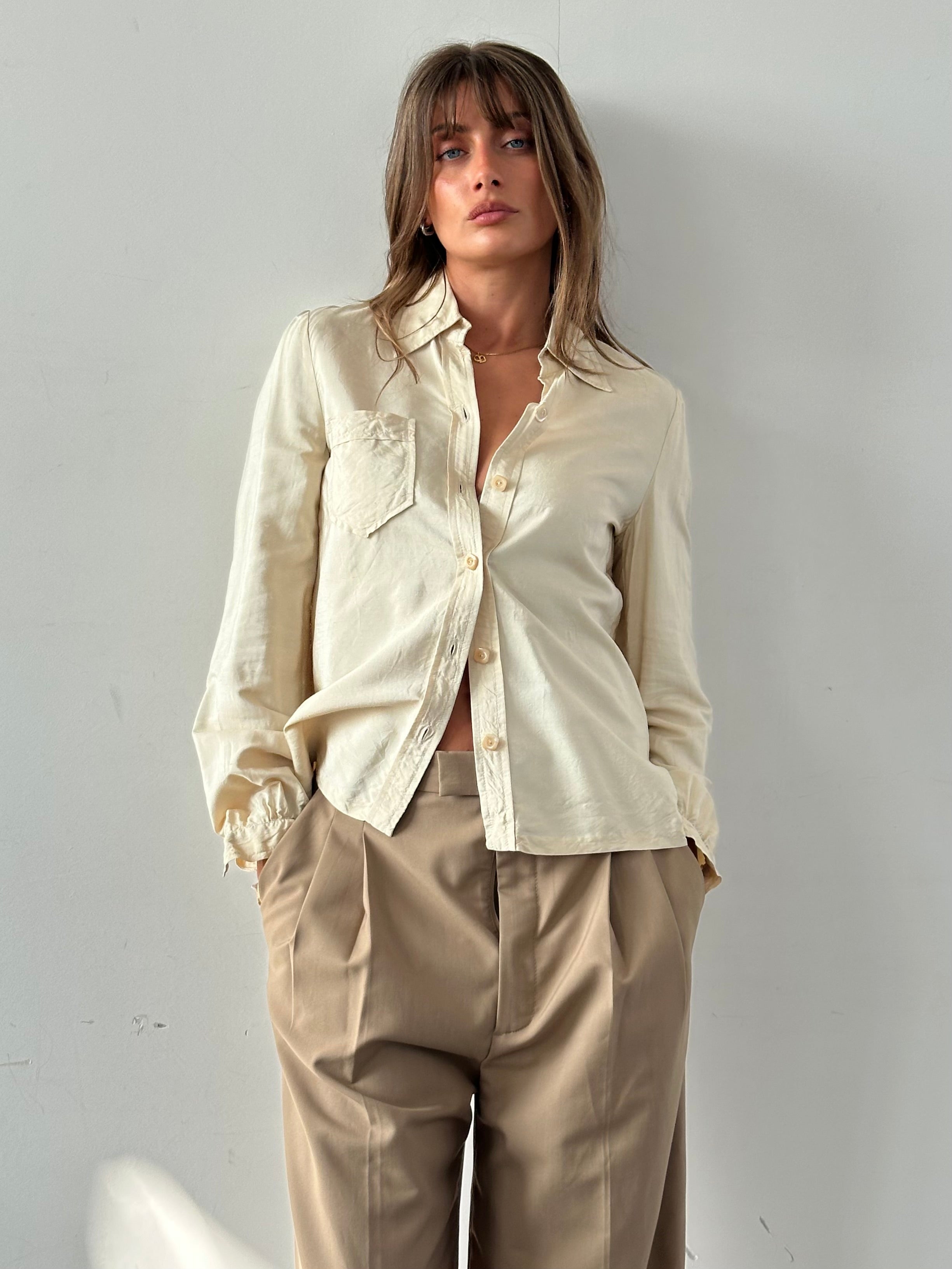 Vintage silk button-up shirt in size small, featuring a classic collar and front buttons, displayed on a hanger.