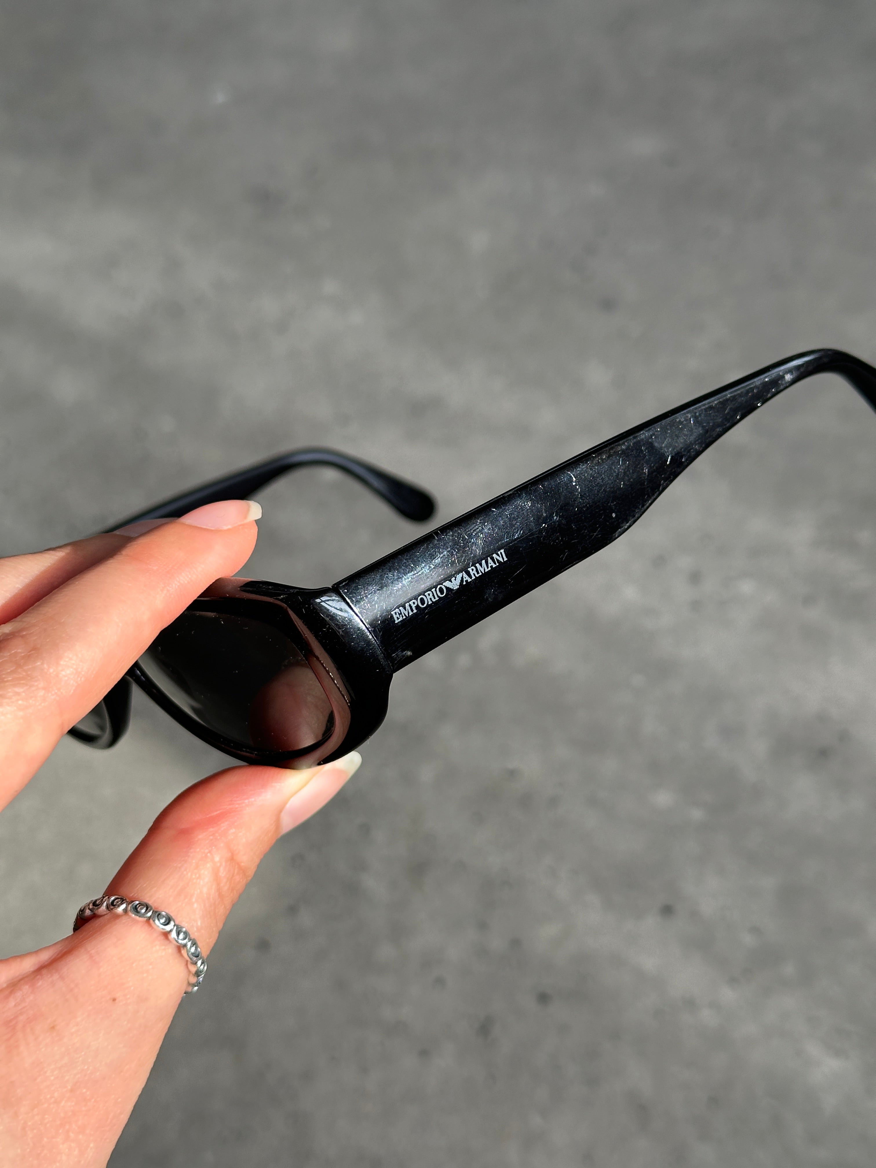 Emporio Armani oval sunglasses with black frames and tinted lenses, stylish and sophisticated eyewear for men and women.