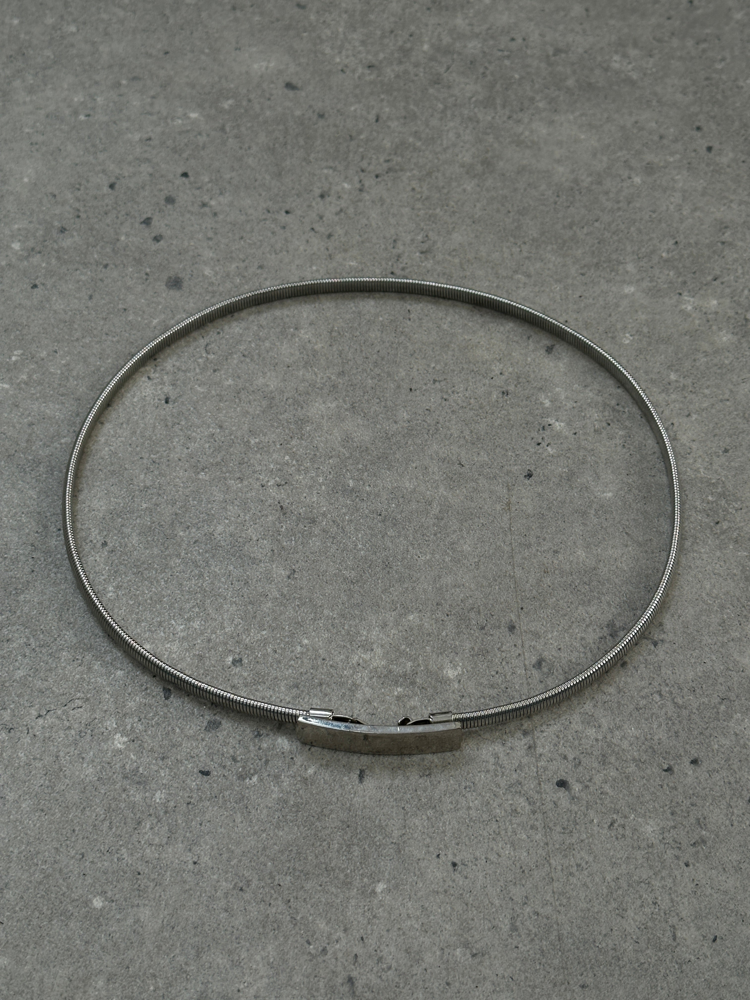 Armani Exchange stretchy metal engraved belt in silver with adjustable 26-30 inch length, featuring intricate engraved details.