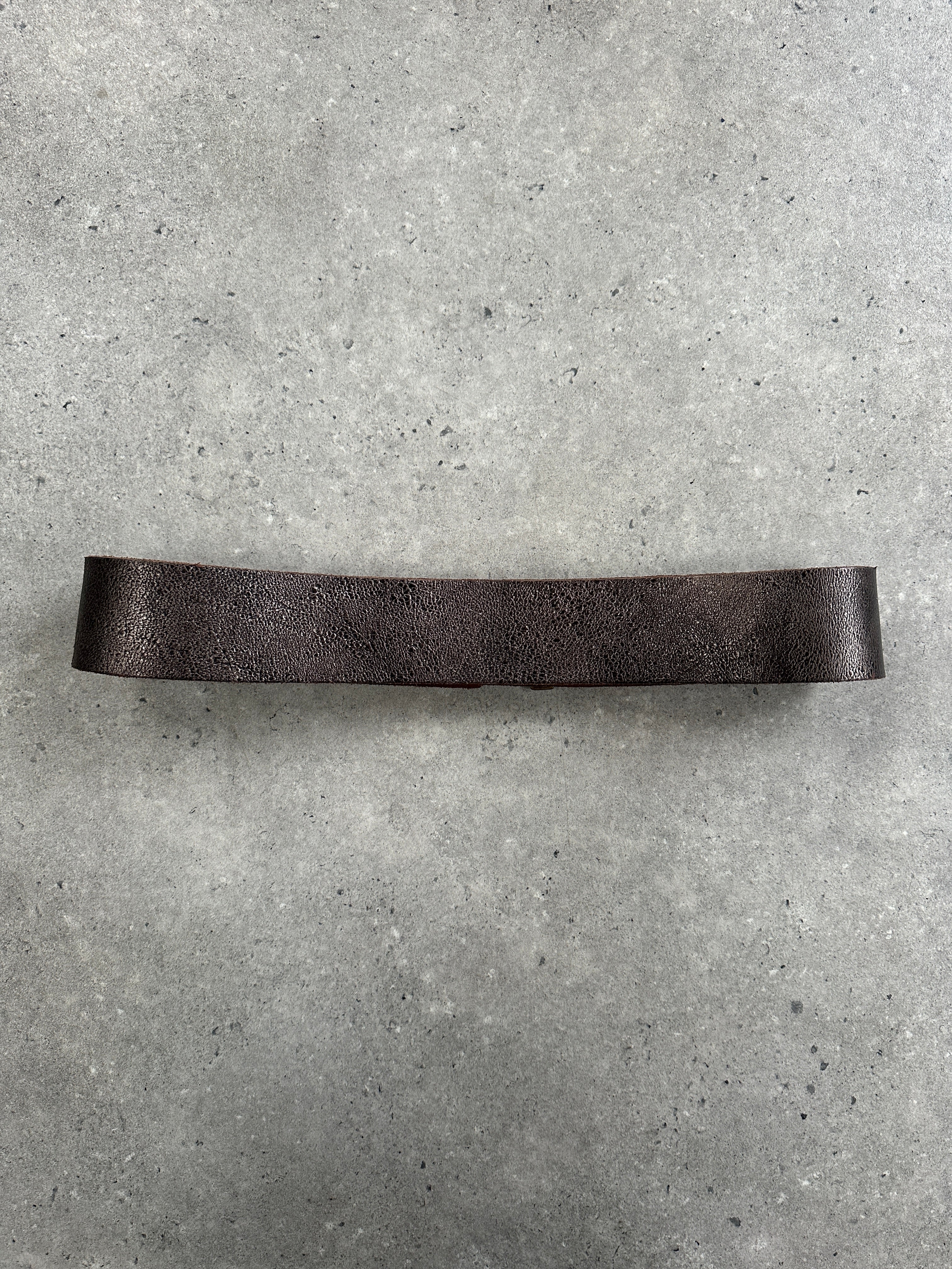 Vintage Italian 1990s distressed metallic leather belt, size W32, featuring a rugged, stylish design with aged metallic finish.