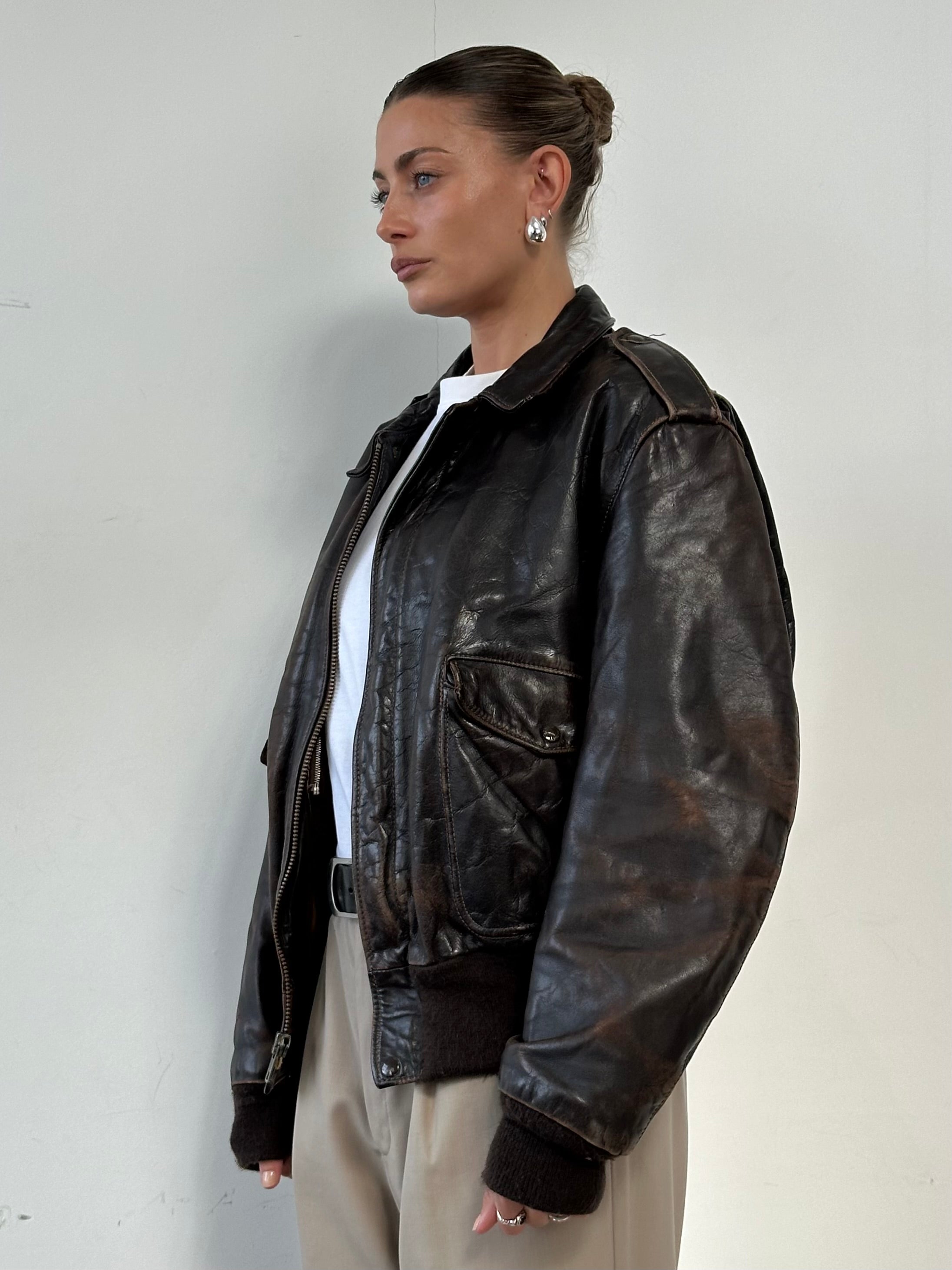 Schott NYC distressed leather bomber jacket in size L/XL, featuring a rugged finish and classic bomber style.