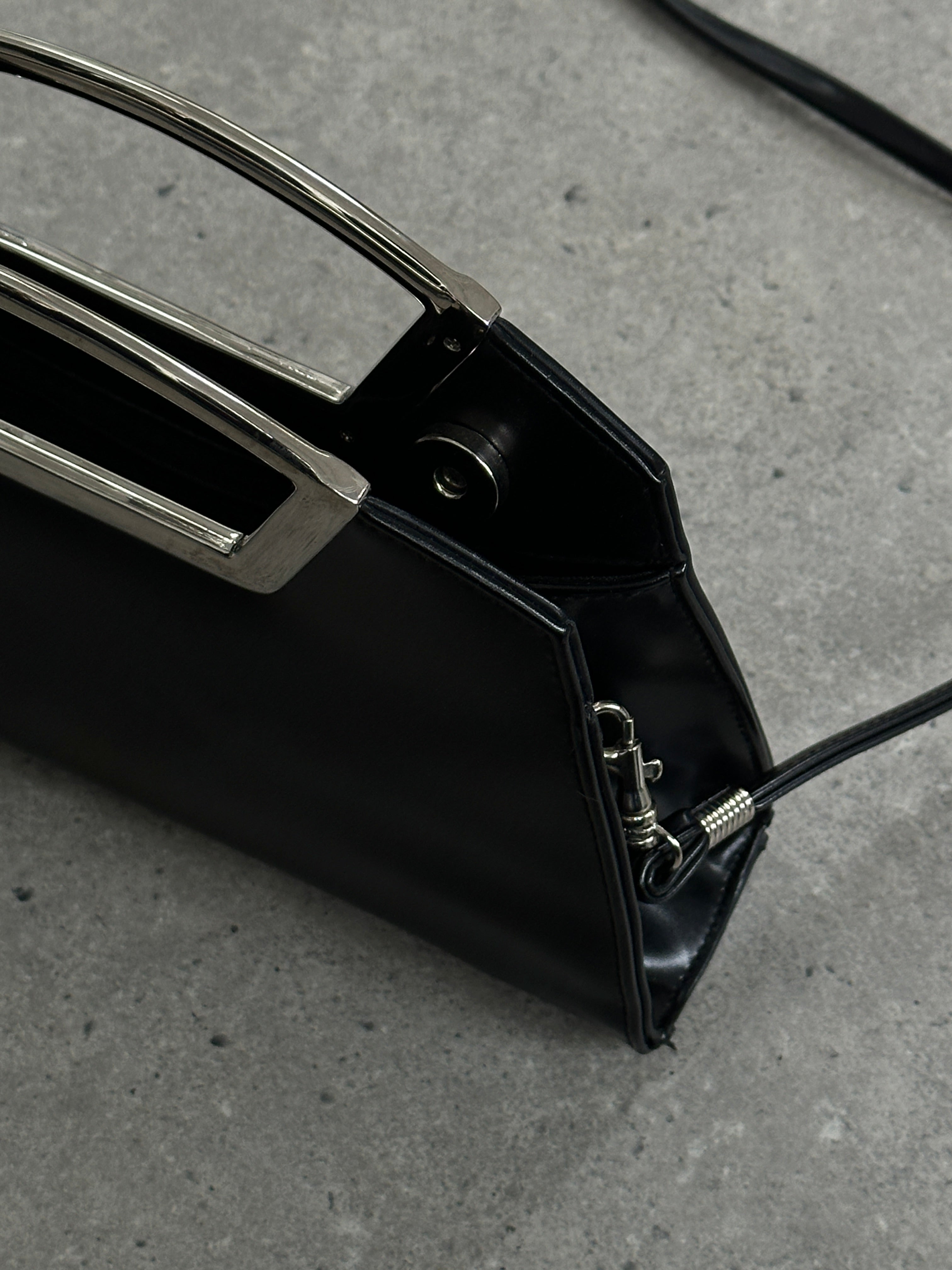 Vintage leather chrome crossbody clutch bag with sleek design and adjustable strap, perfect for stylish everyday use.