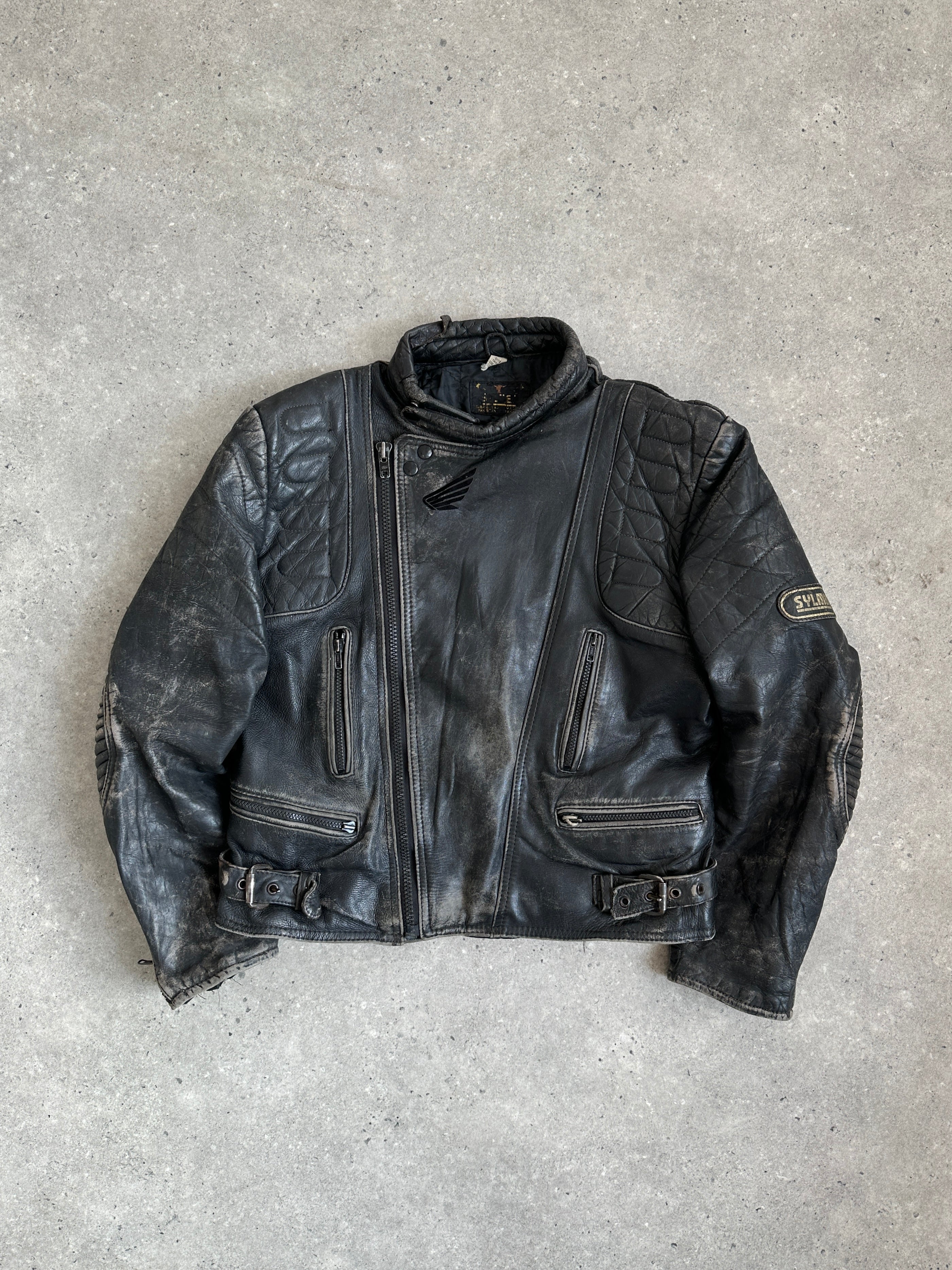 Vintage brand distressed leather motorcycle jacket in size M/L with rugged, worn-in look and classic style.