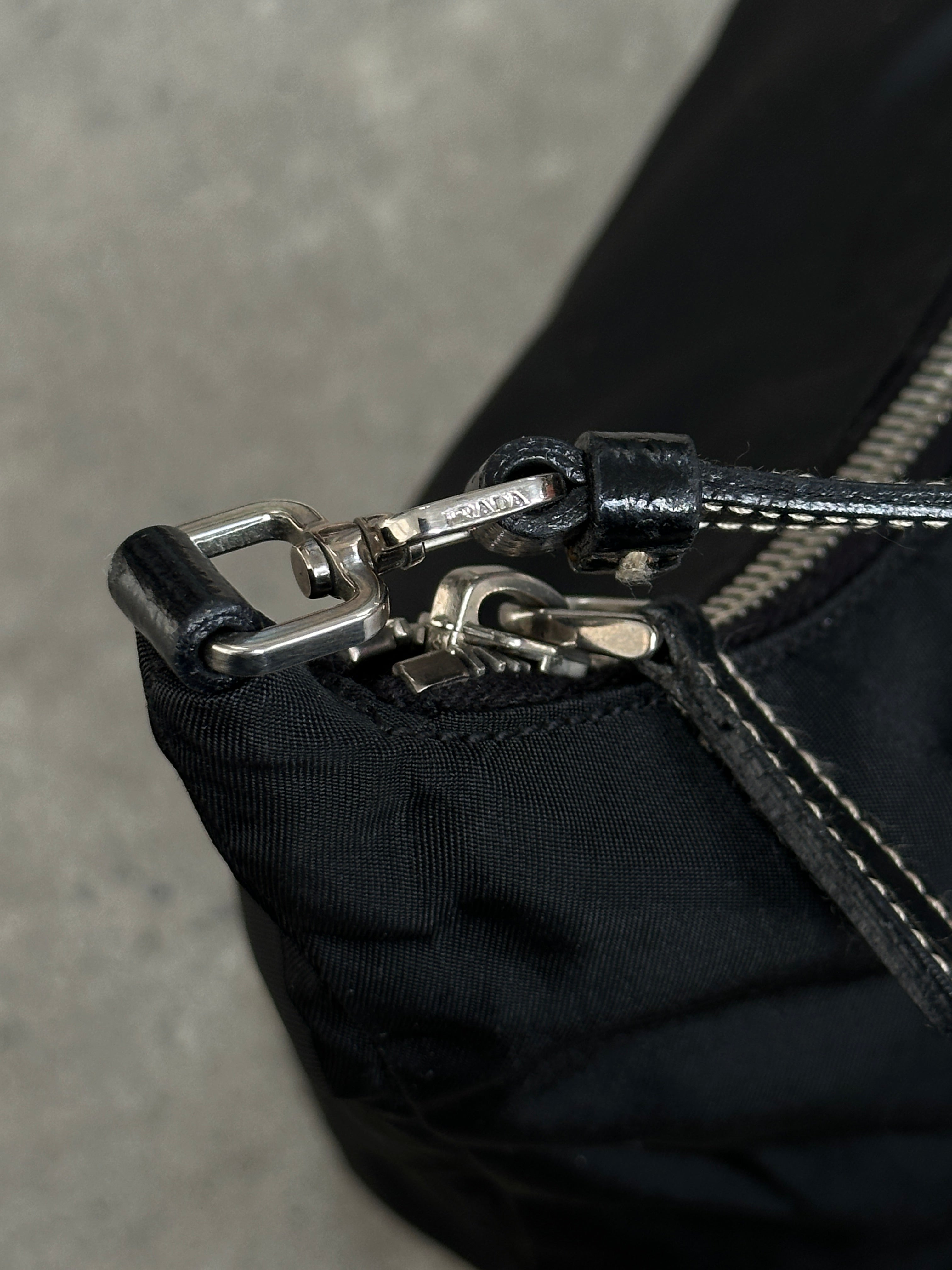 Prada nylon shoulder bag with chrome logo hardware, featuring a sleek design and adjustable strap.