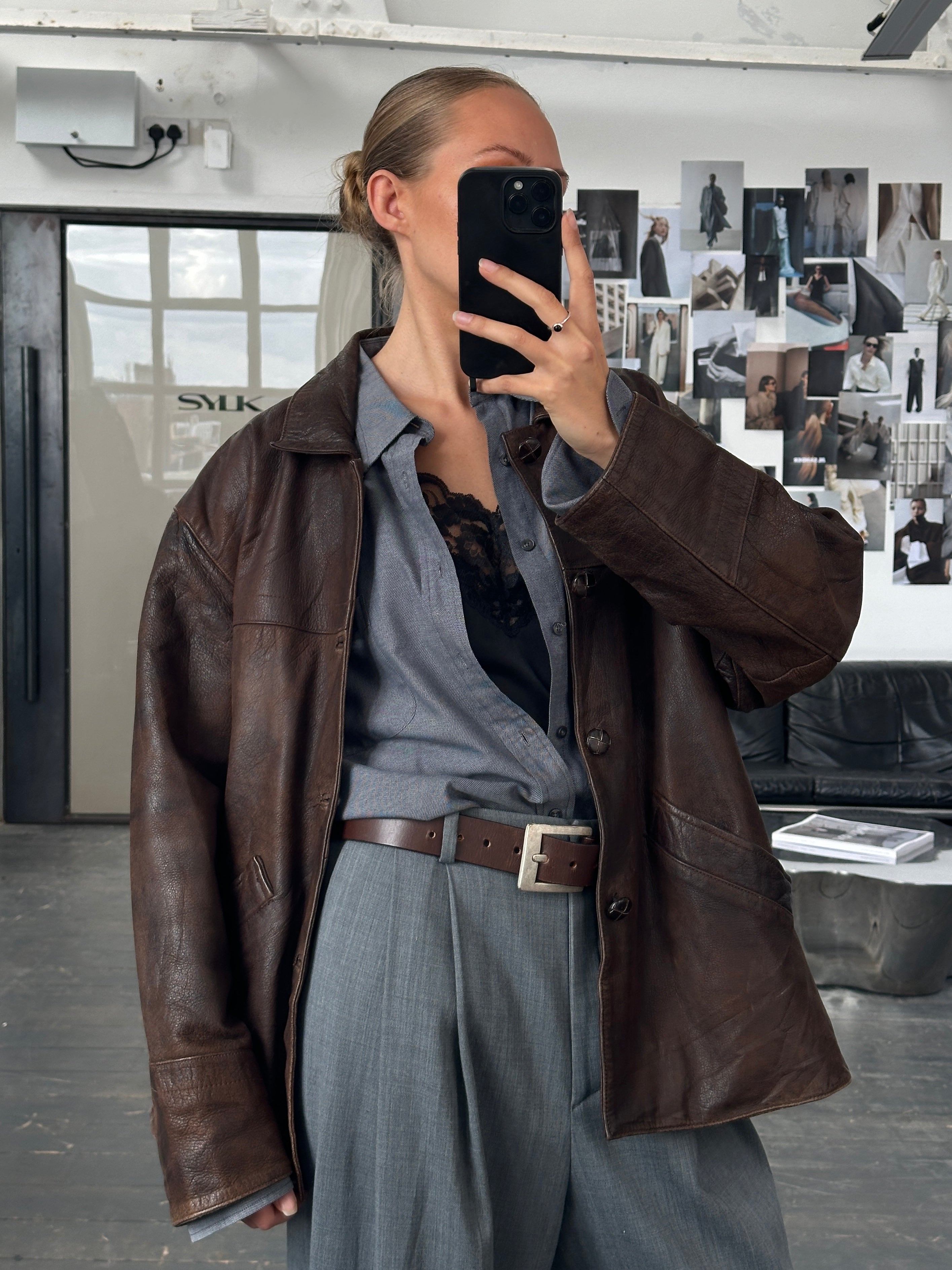 Vintage brand vintage 1980s aged boxy leather jacket in XL with distressed finish and classic design, displayed on a hanger.