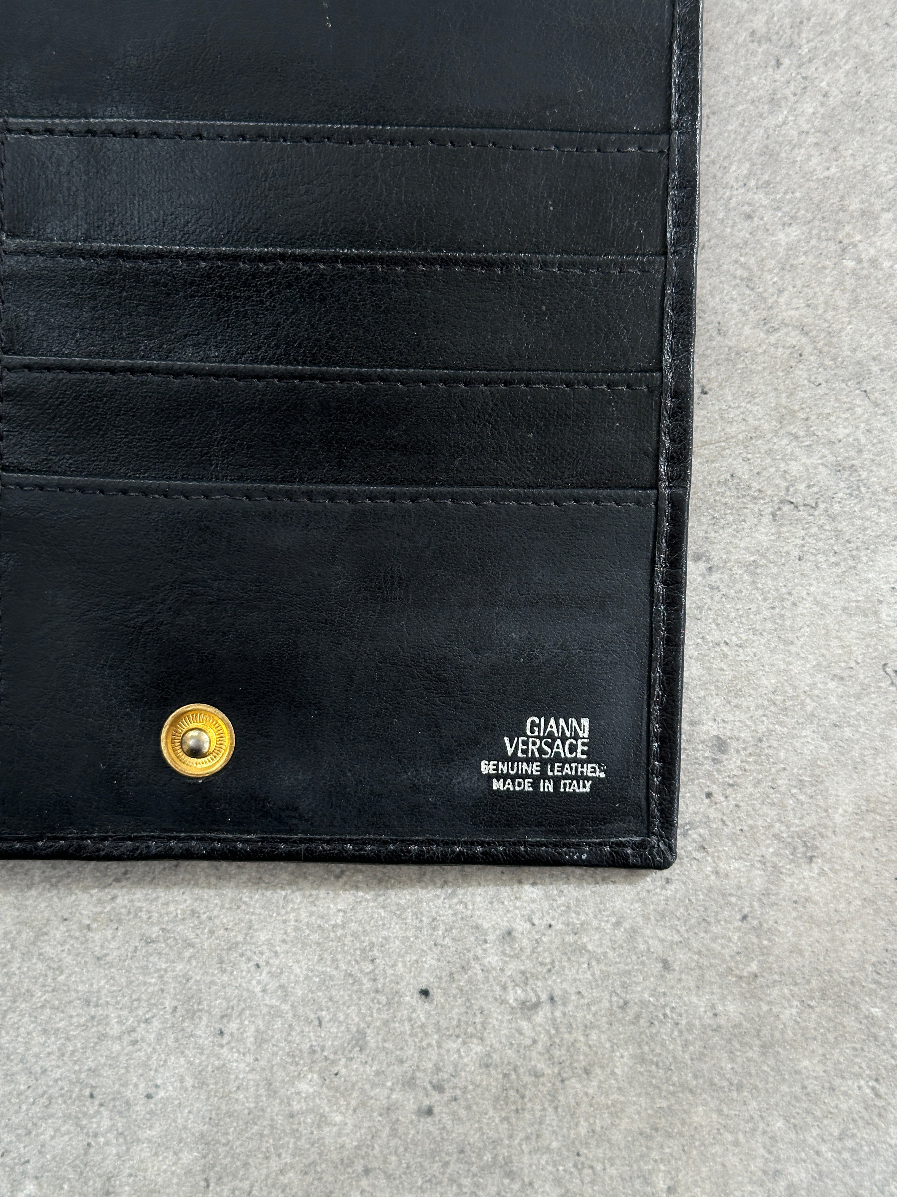Armani leather crossbody bag featuring Medusa embellishment, 1990s Gianni Versace style, with adjustable strap and classic design.