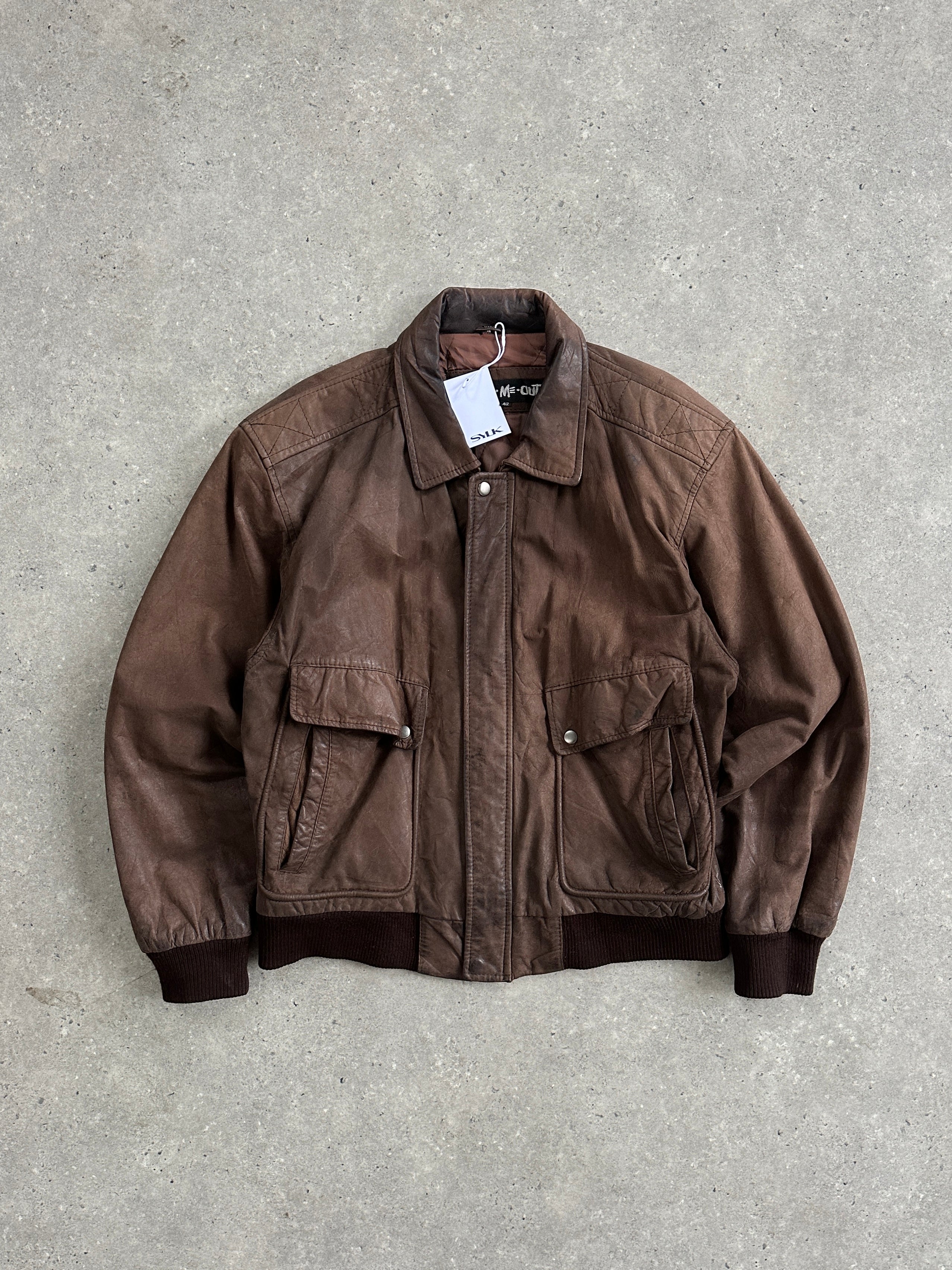 Vintage leather bomber jacket in size L, featuring classic design with ribbed cuffs and collar, showcased on a hanger.