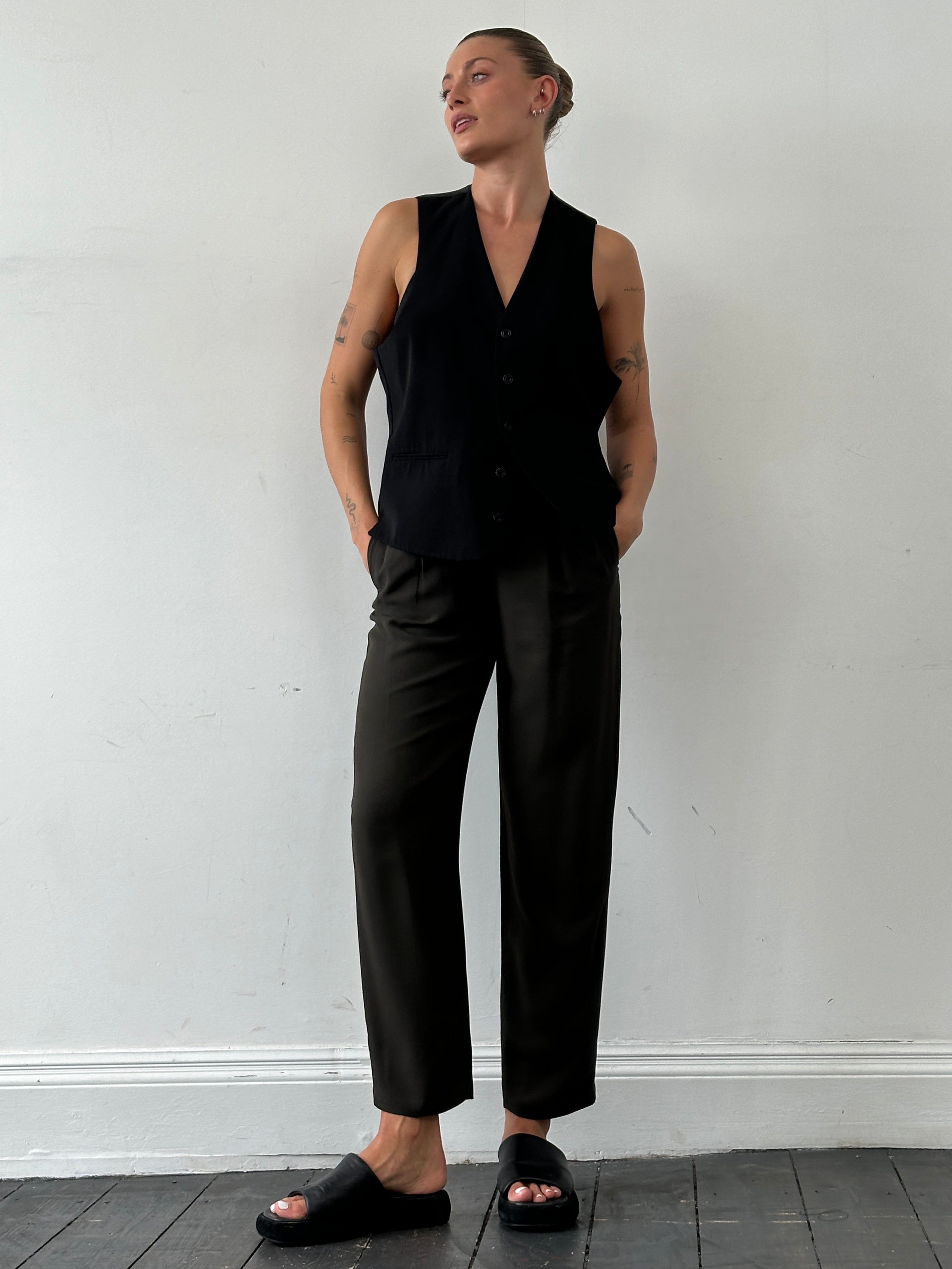 Emporio Armani high waisted tapered leg tailored trousers in dark fabric, shown on a model, with front view and belt loops.