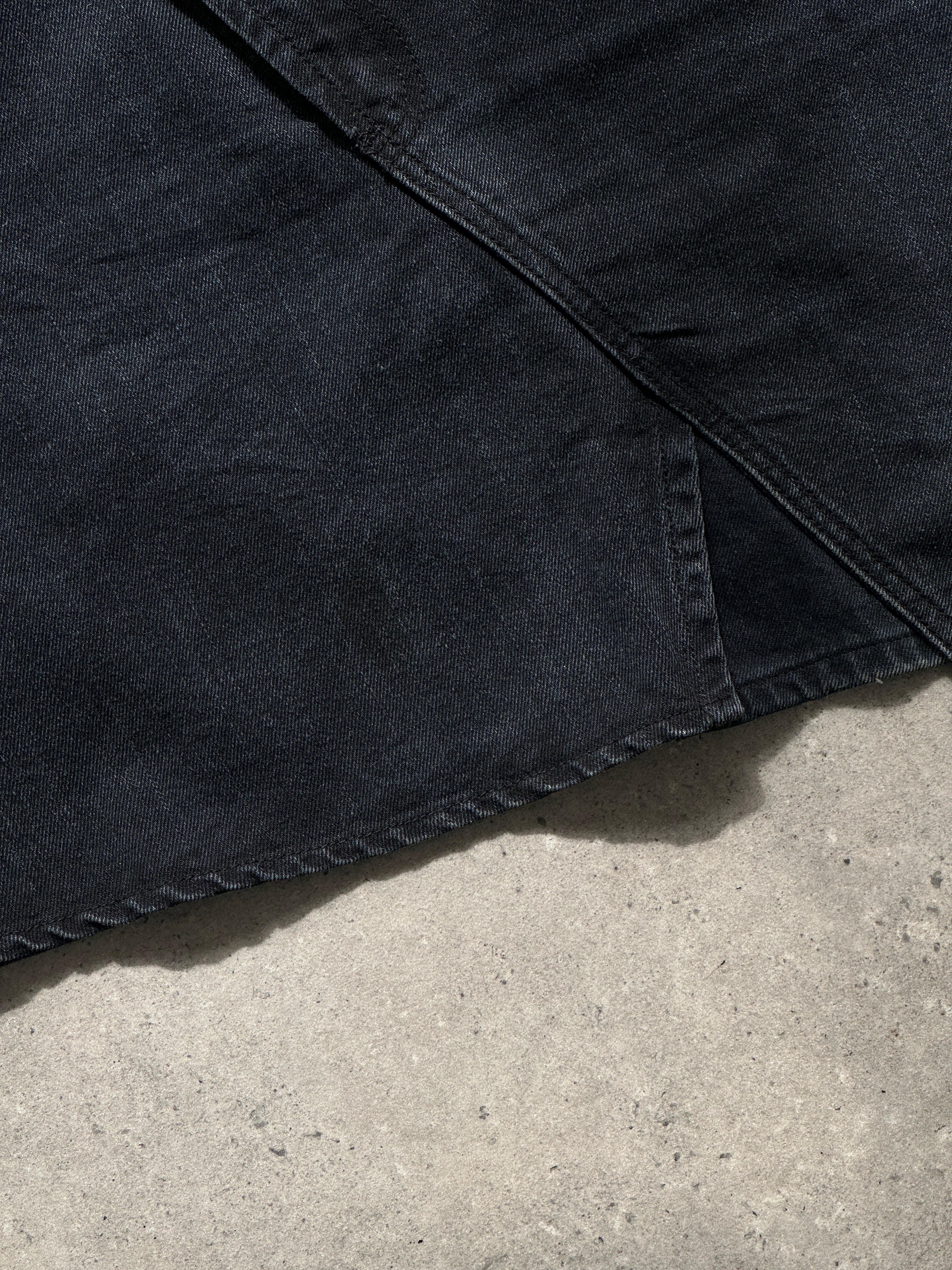 Vintage asymmetrical denim mini skirt, W32, featuring a stylish, distressed design with a high waist and unique hem detail.
