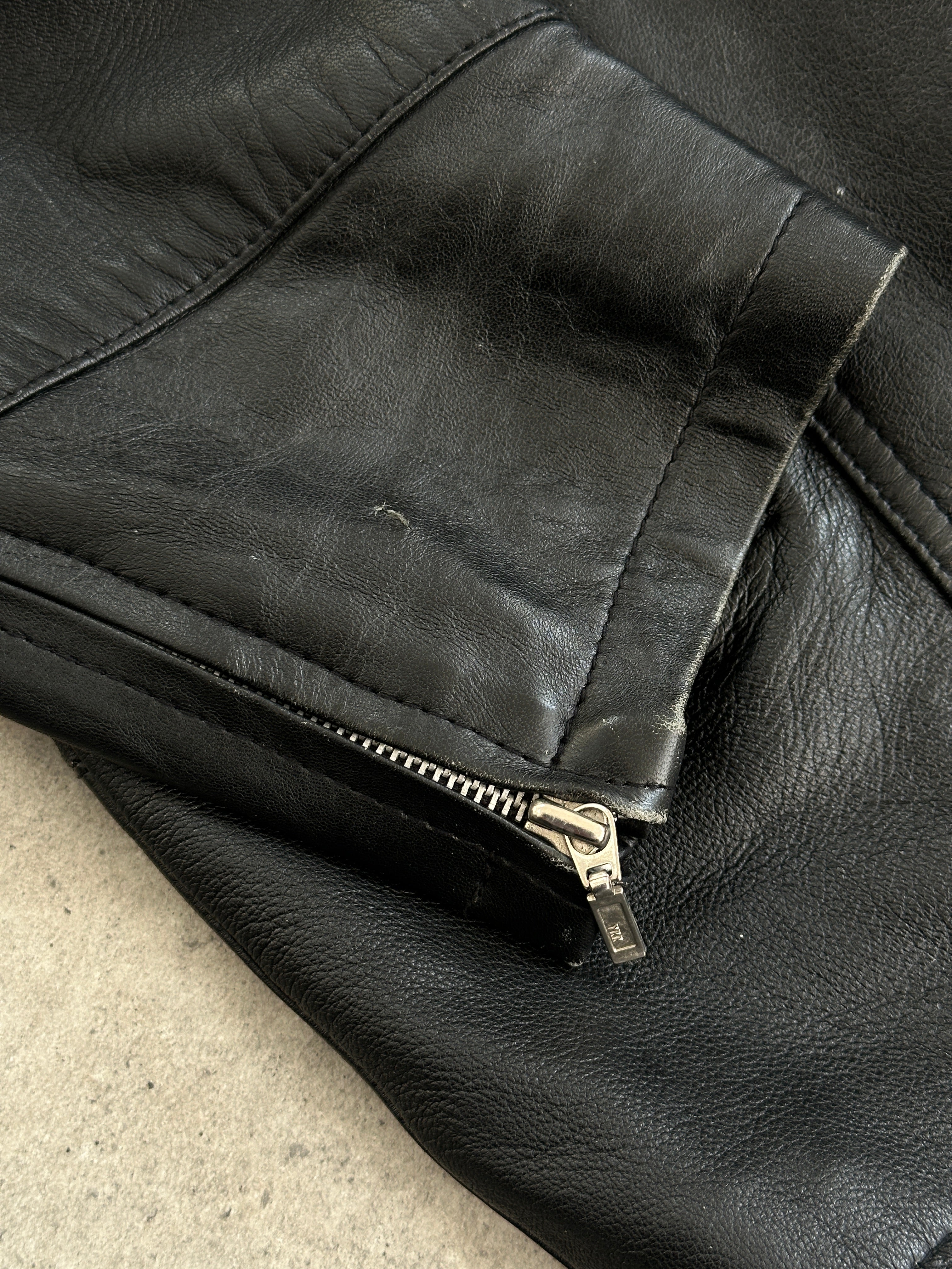 Vintage high neck leather jacket with removable hood, in black, featuring a classic design and silver zipper details.