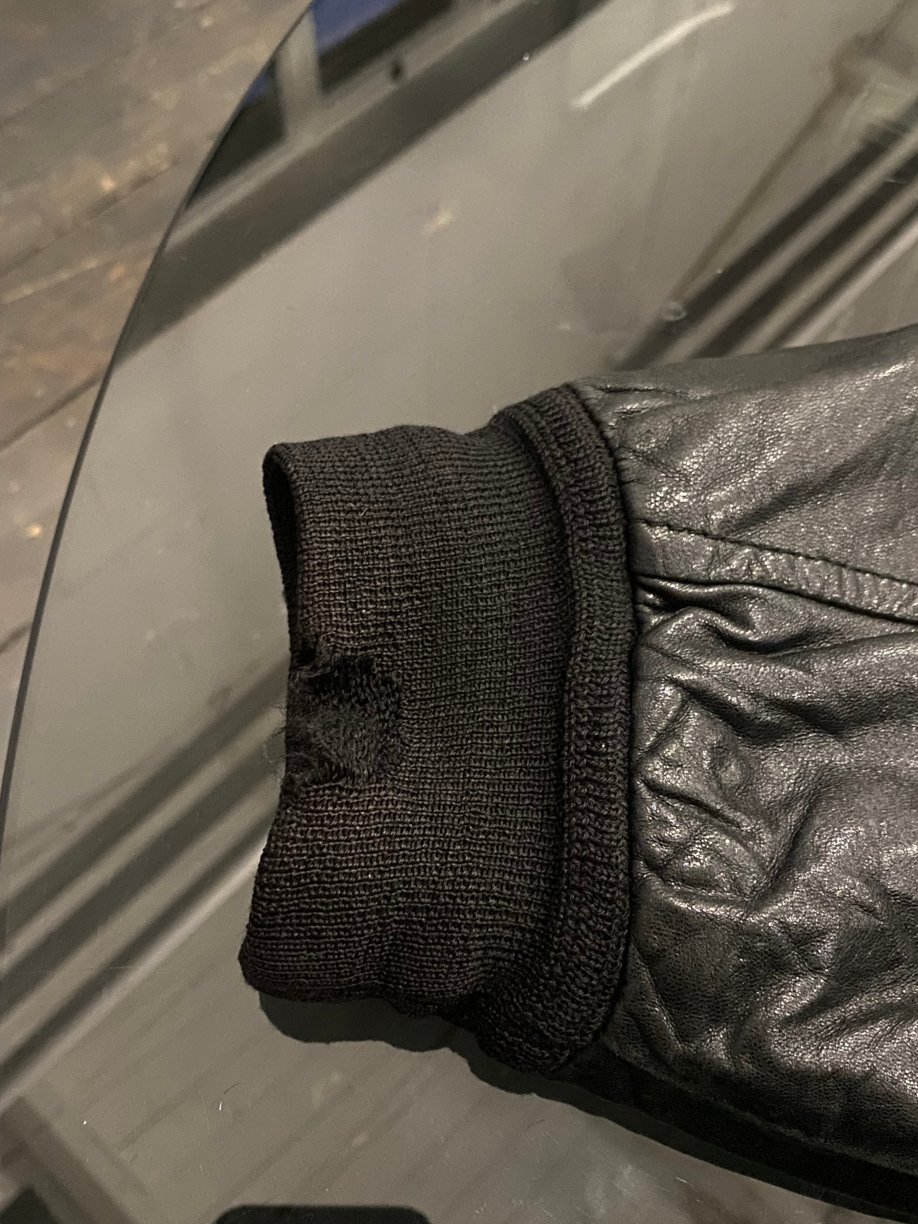 Vintage leather bomber jacket in size large, featuring classic design with ribbed cuffs and collar, on a hanger.