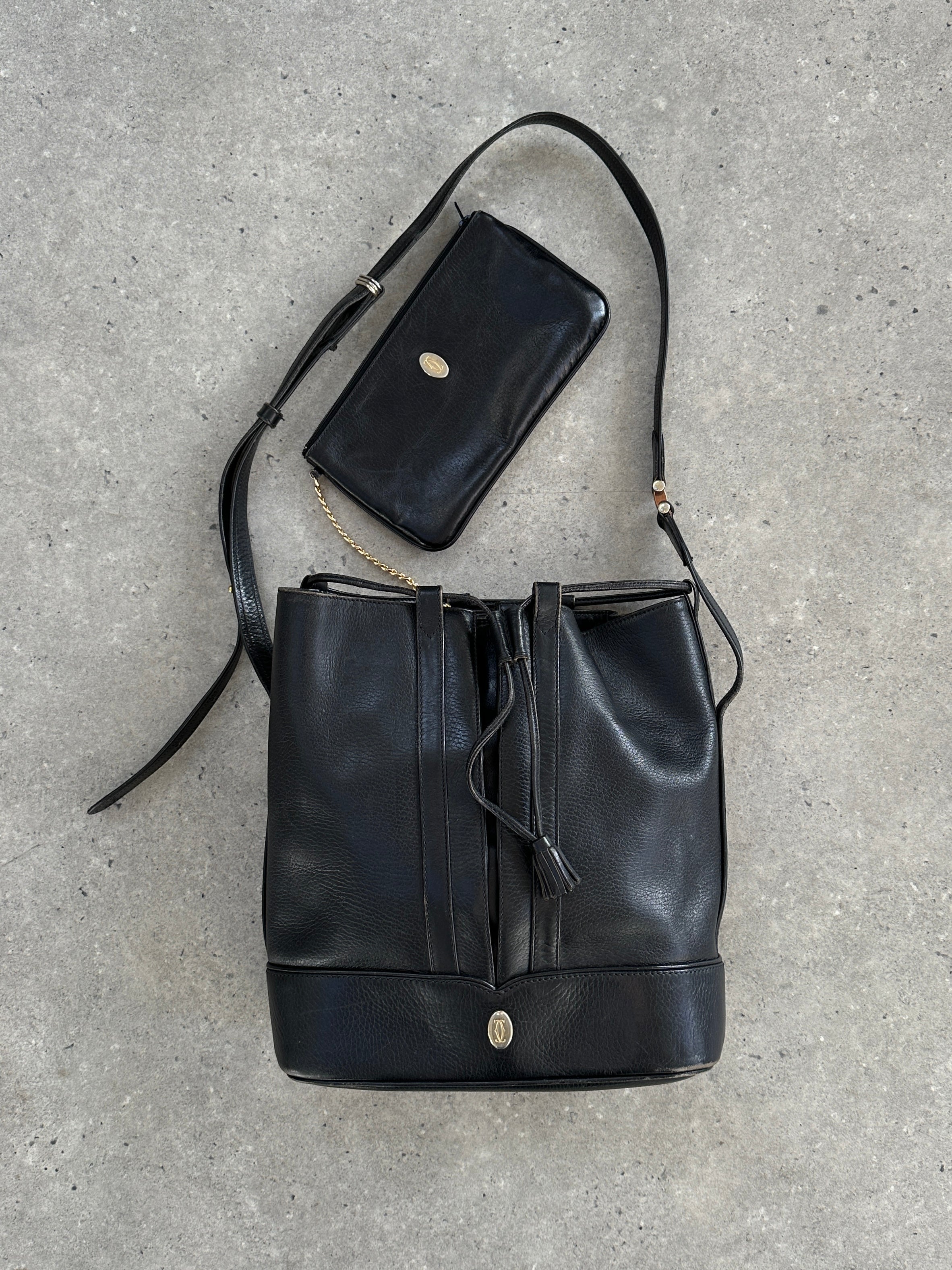 Cartier 1980s leather bucket bag with adjustable strap and classic design, showcasing luxurious craftsmanship and vintage style.