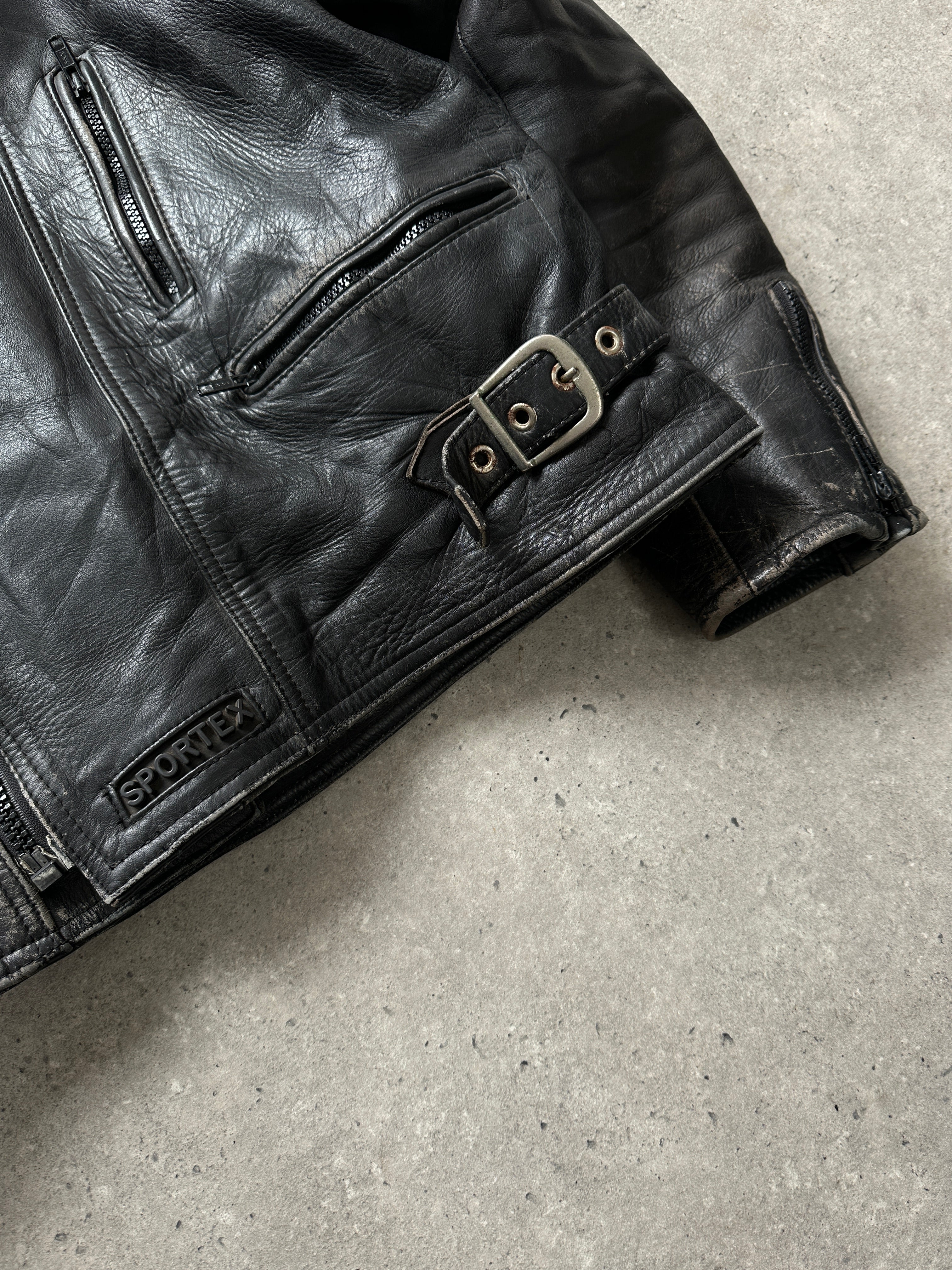 Vintage distressed motorcycle leather jacket in size L/XL, featuring rugged design and classic style with visible stitching and worn leather texture.