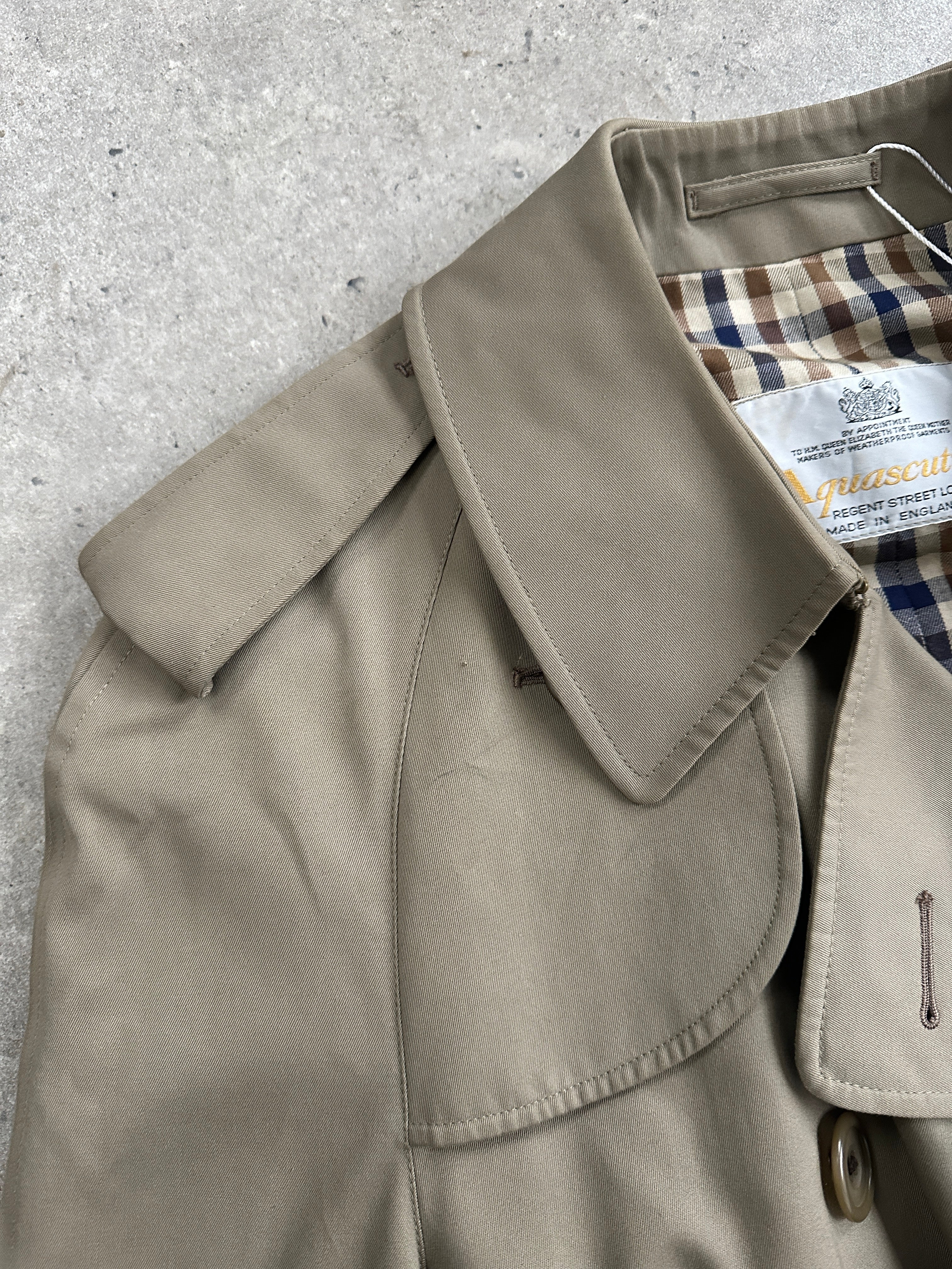 Aquascutum pure cotton double-breasted belted trench coat in size XL, shown on a hanger with classic beige color and tailored fit.