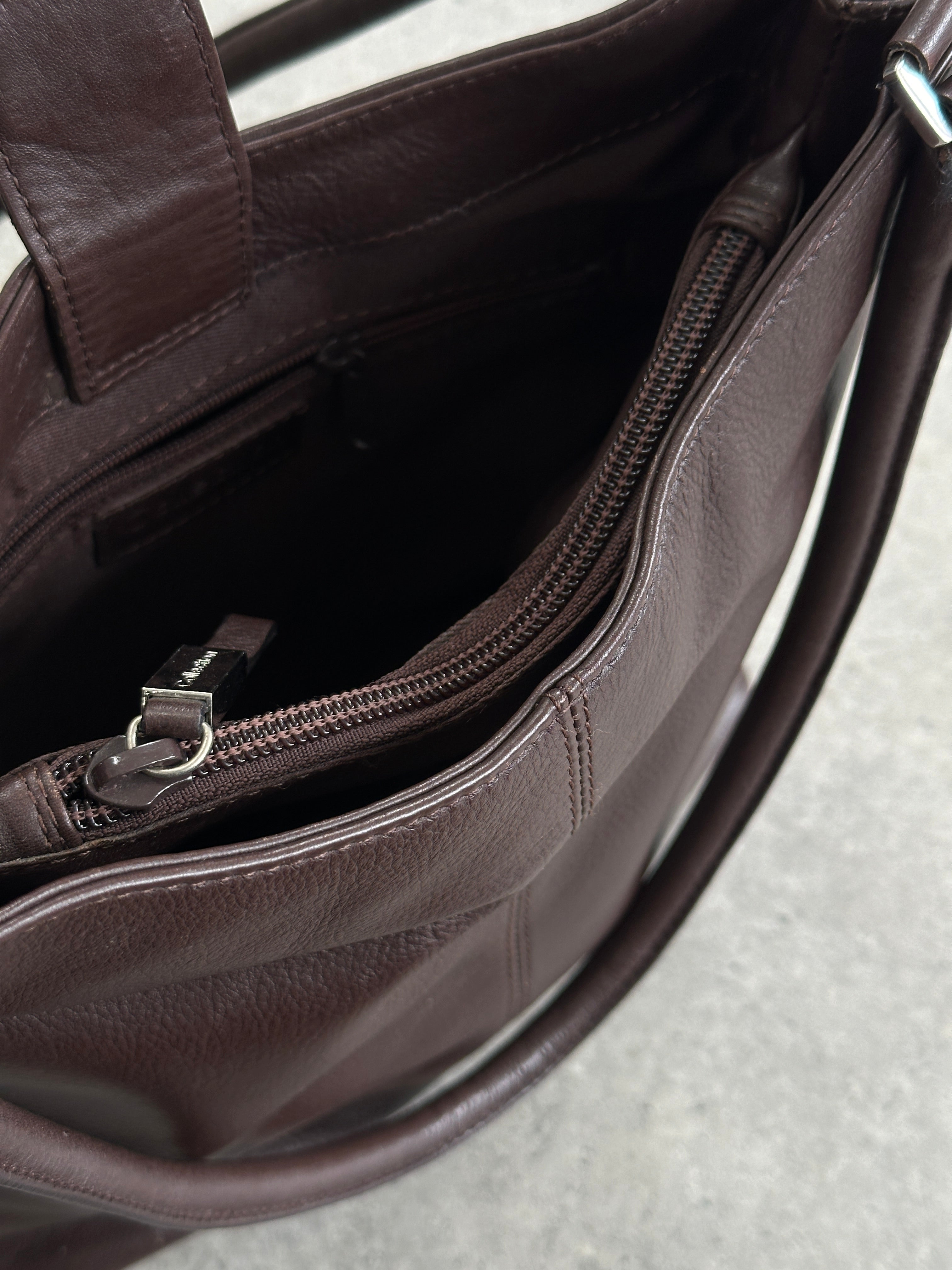 Vintage leather shoulder bag with adjustable strap, featuring classic design and detailed stitching.