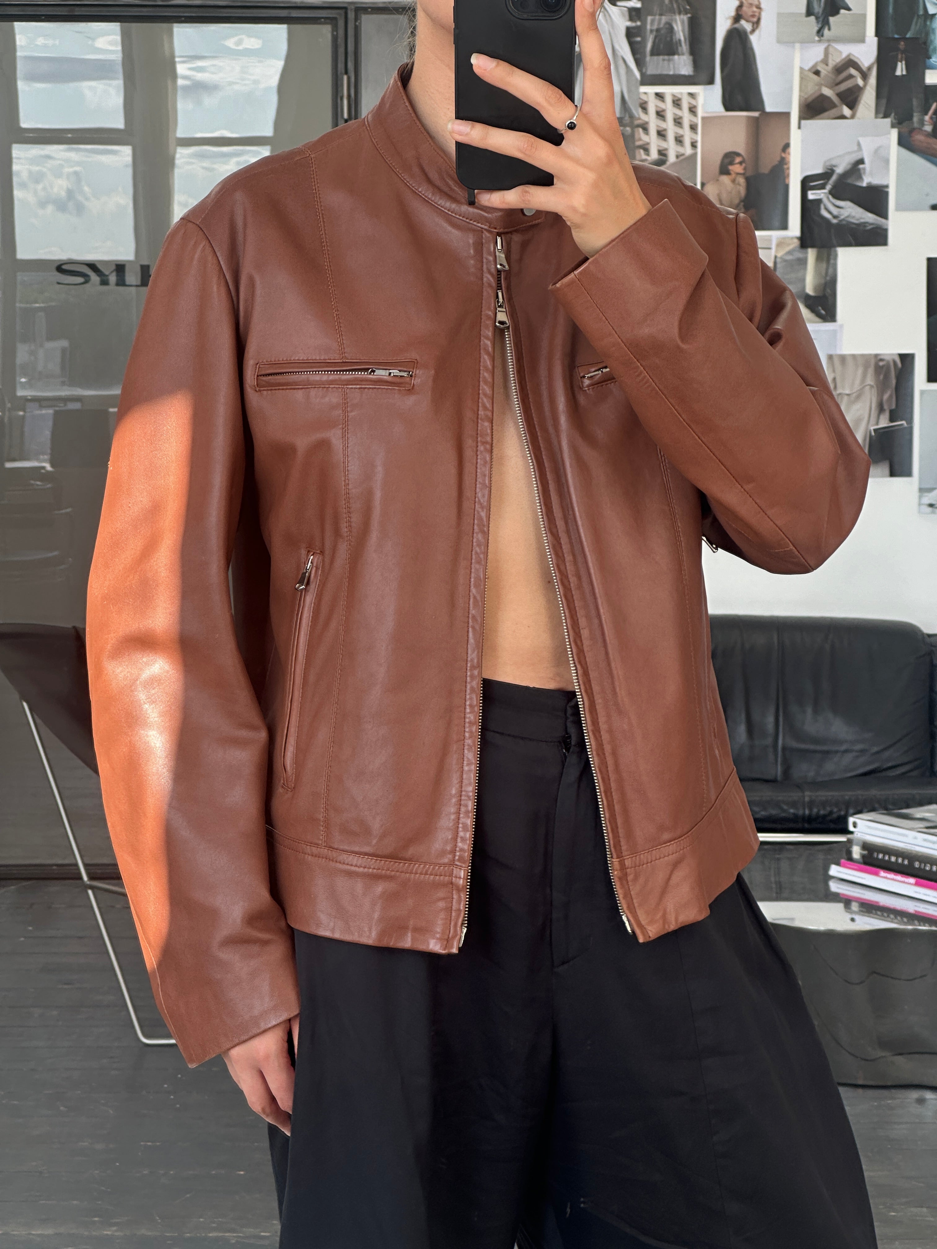 Vintage Italian 90s double zip leather moto jacket with classic style and hardware, displayed on a hanger.