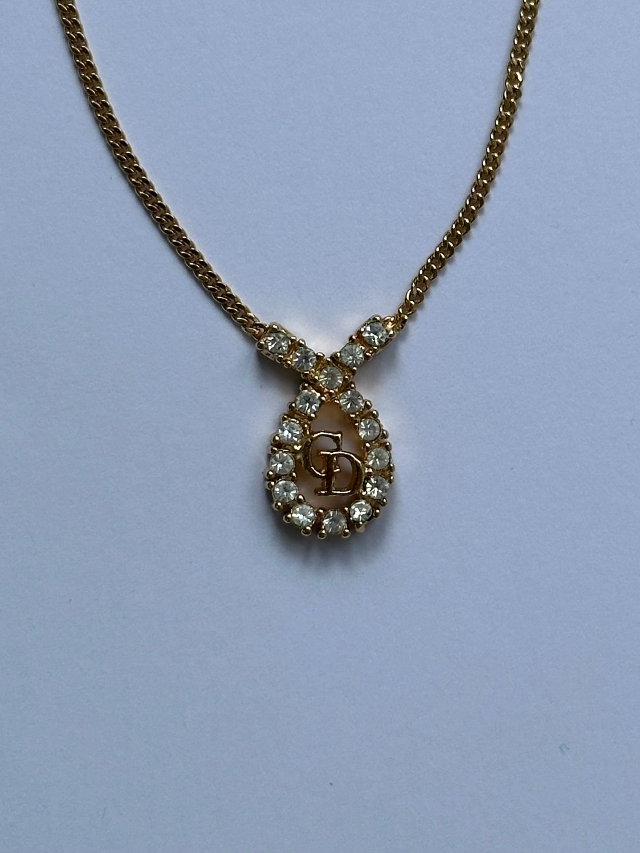 Christian Dior 16-inch gold plated rhinestone drop logo pendant necklace, featuring a sparkling Dior logo charm.