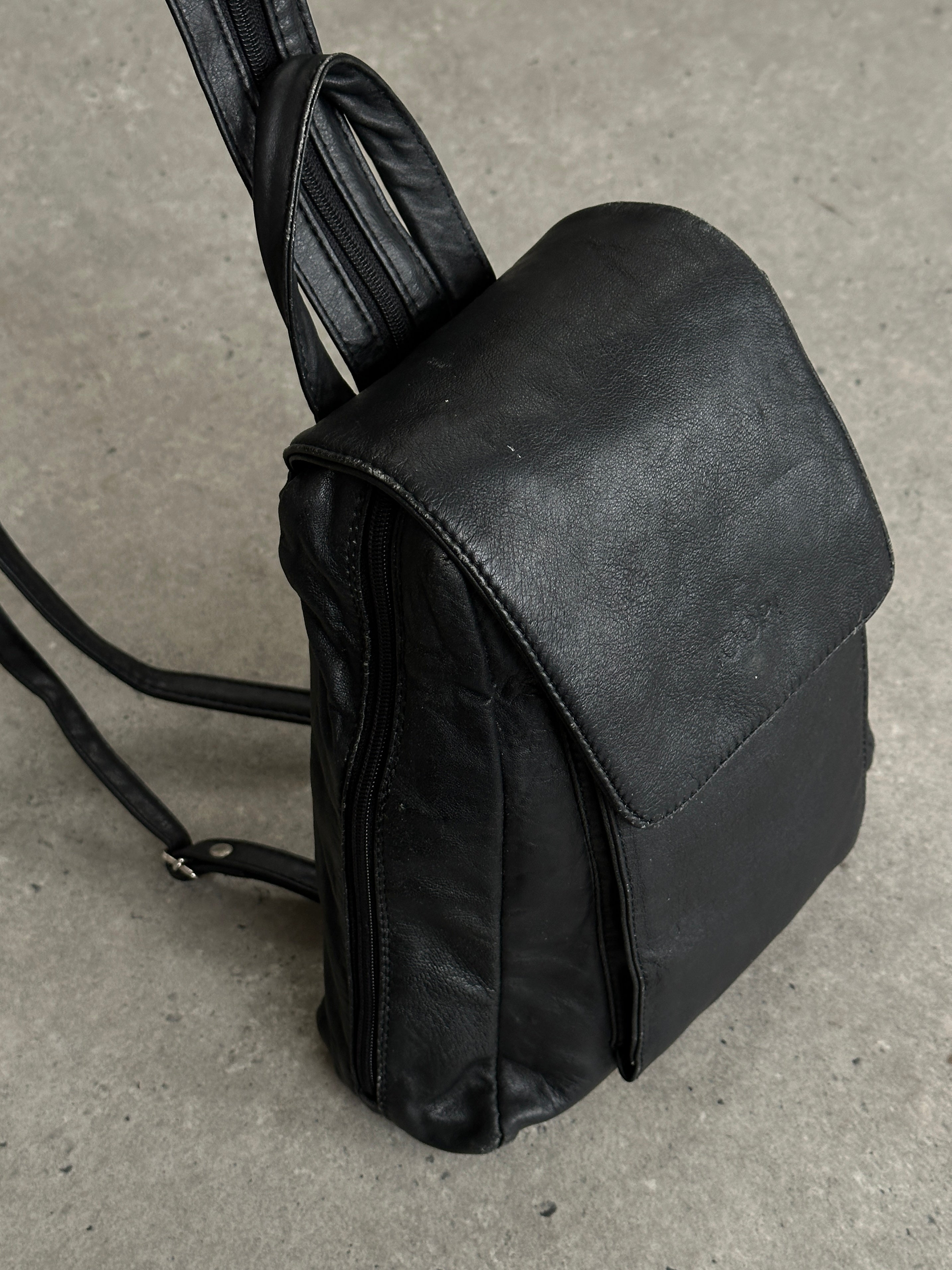 Vintage faux leather rucksack bag with adjustable straps and classic design, suitable for casual or outdoor use.